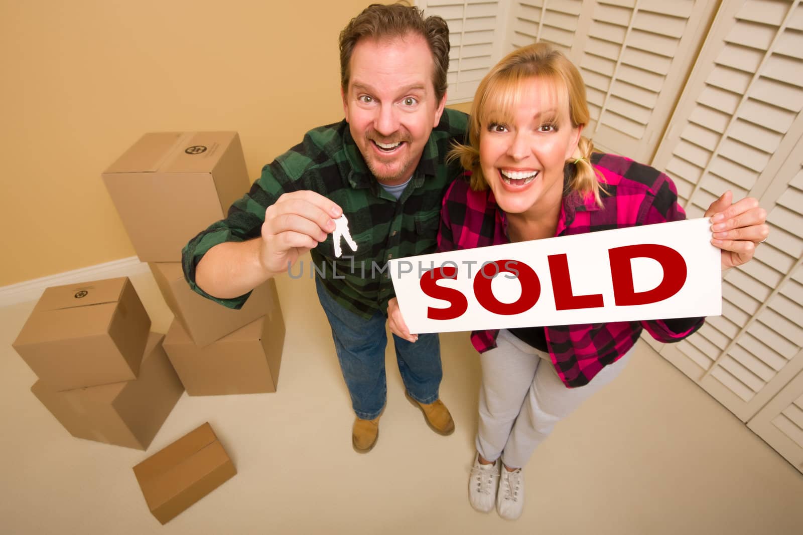 Goofy Couple Holding Key and Sold Sign Surrounded by Boxes by Feverpitched