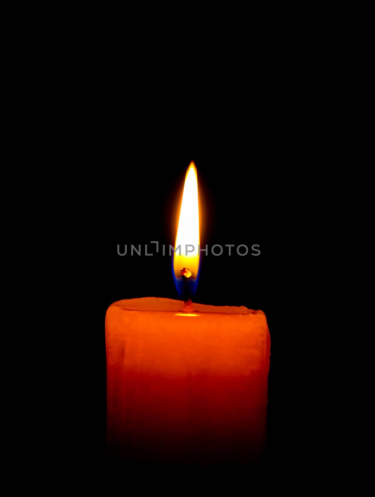 A single burning  candle isolated on  black