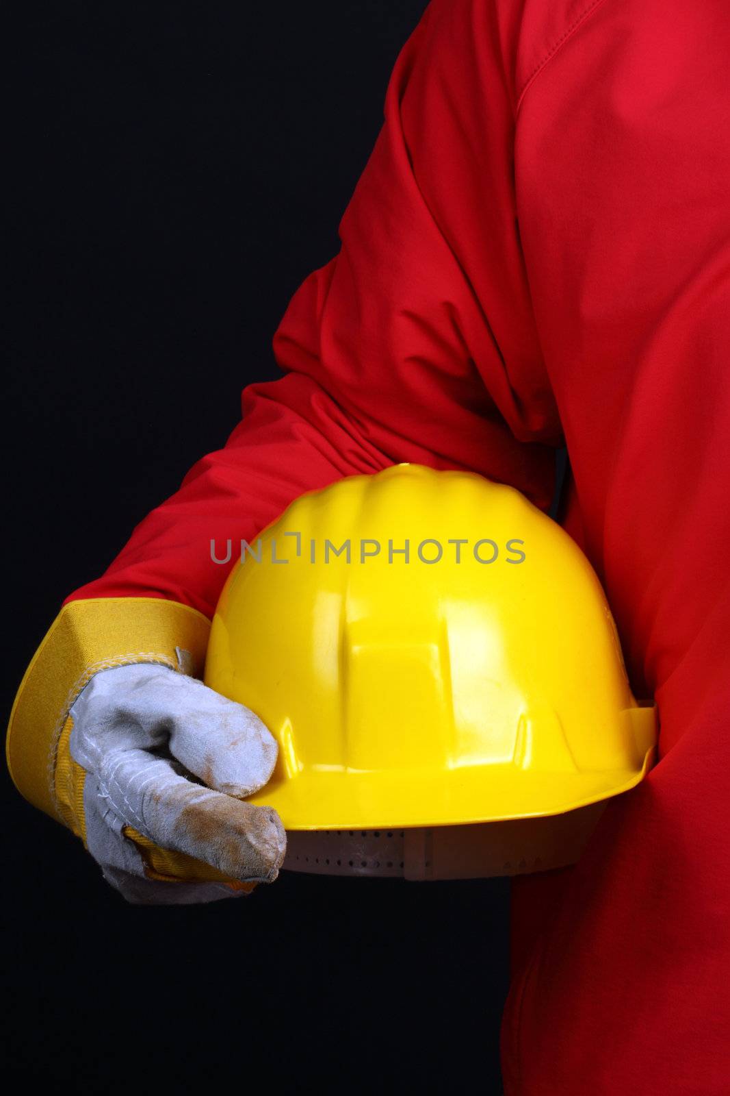 man holding yellow helmet over black background 