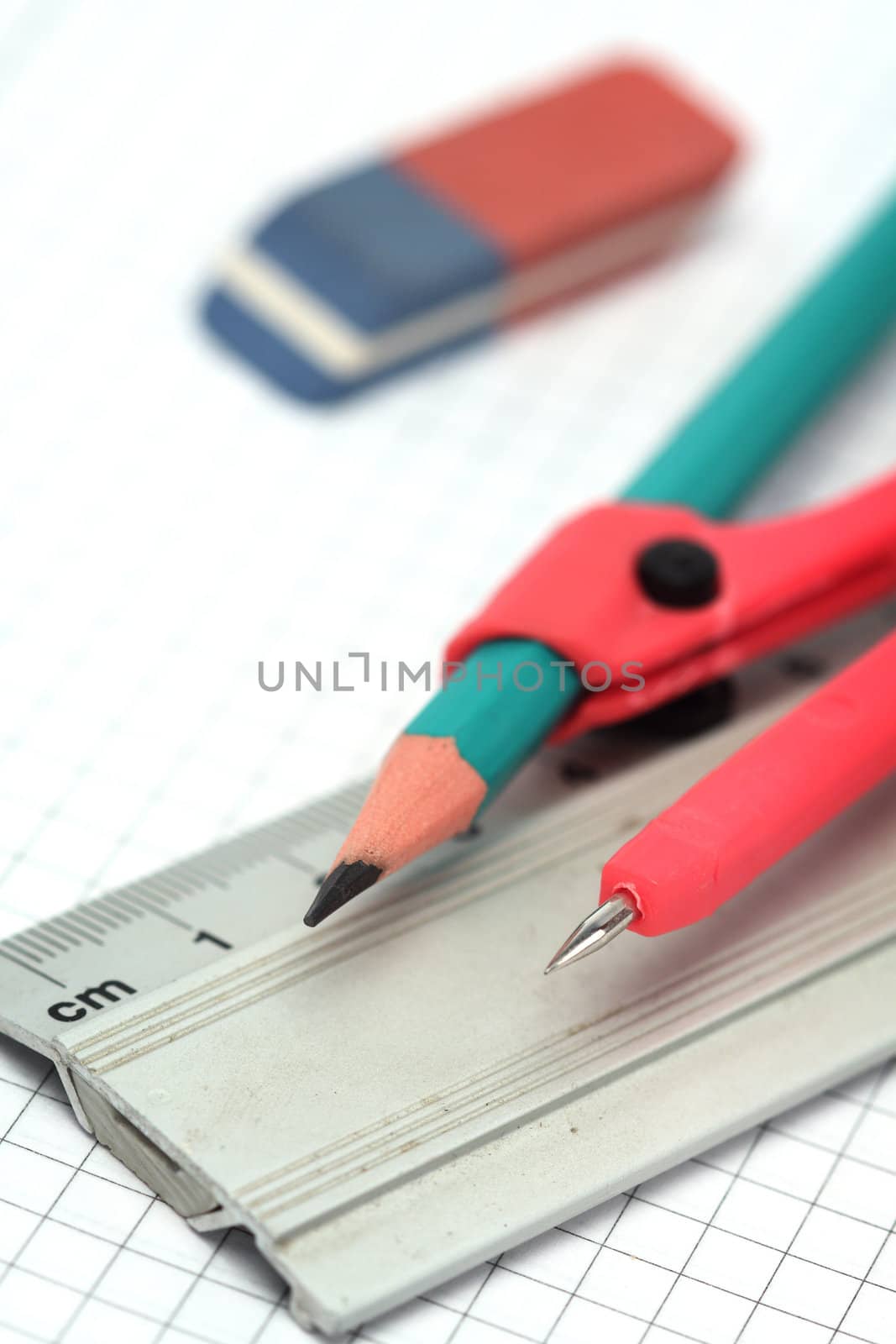 Close up of compasses, pencil, eraser and ruler