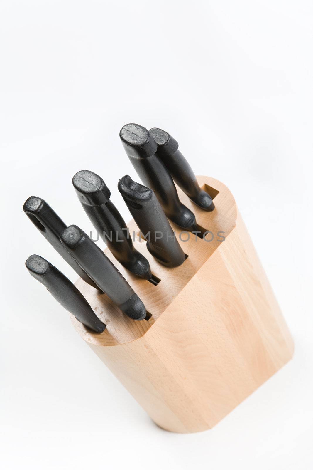 Kitchen knives in a wooden block on a white background