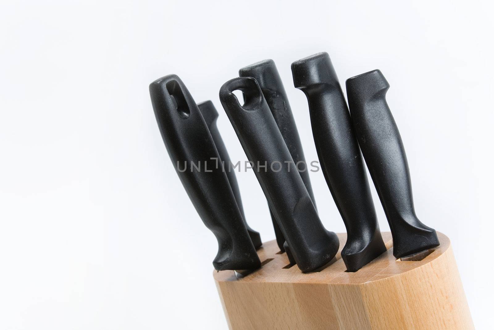 Kitchen knives in a wooden block on a white background