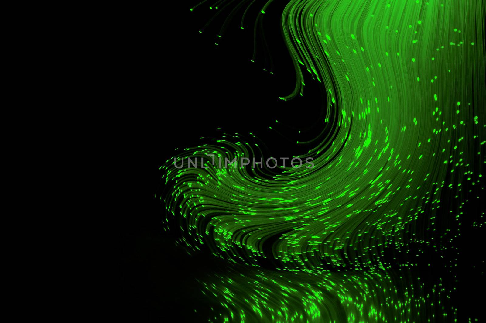 Bright green fiber optic light strands swirling against a black background and reflecting into the foreground.