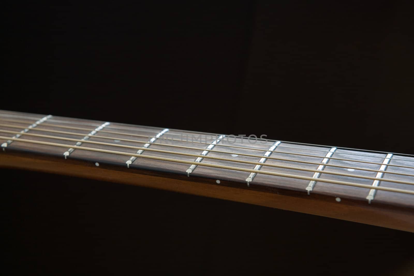 Acoustic guitar neck over dark background