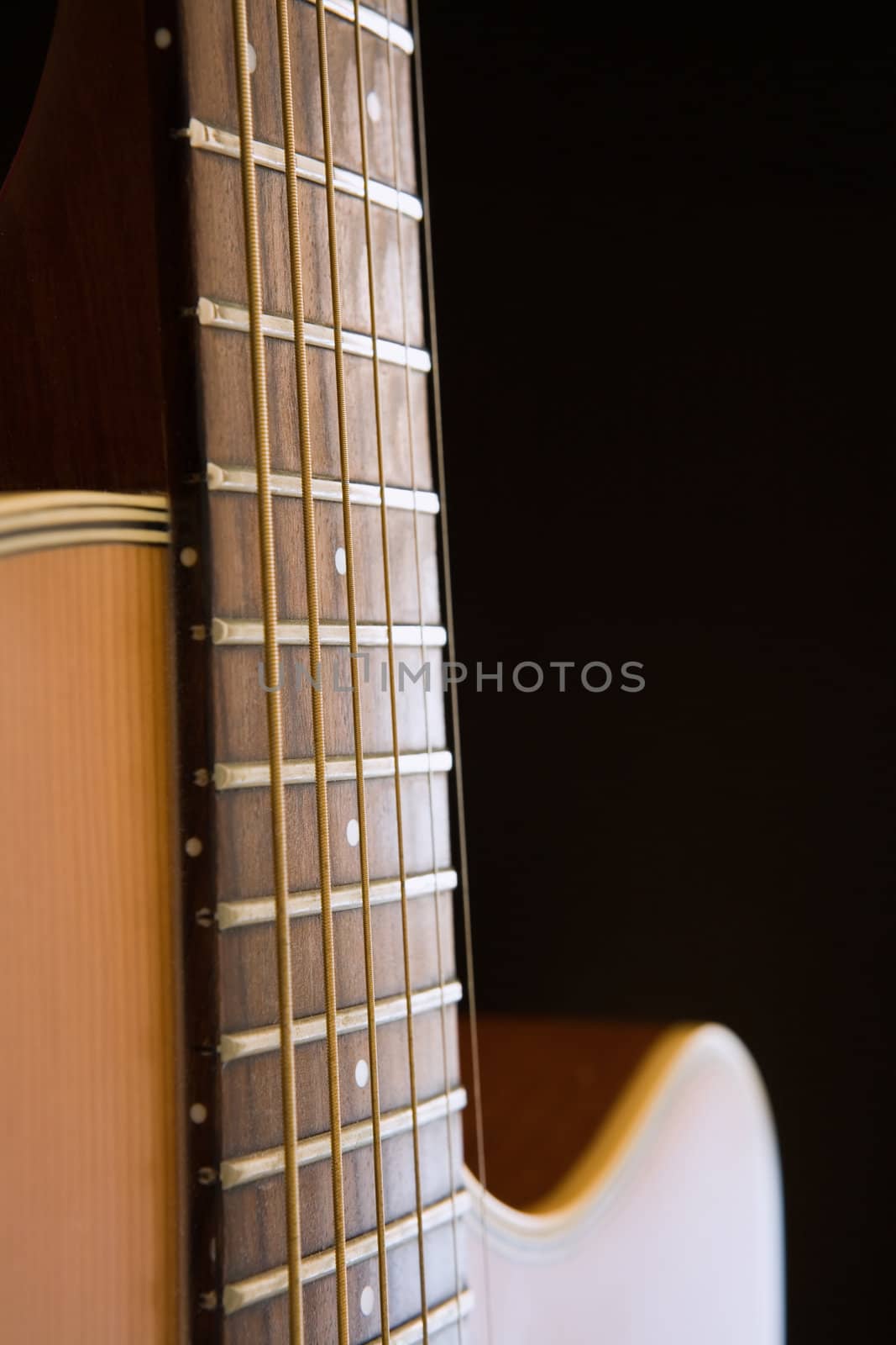 Acoustic guitar close-up over dark background