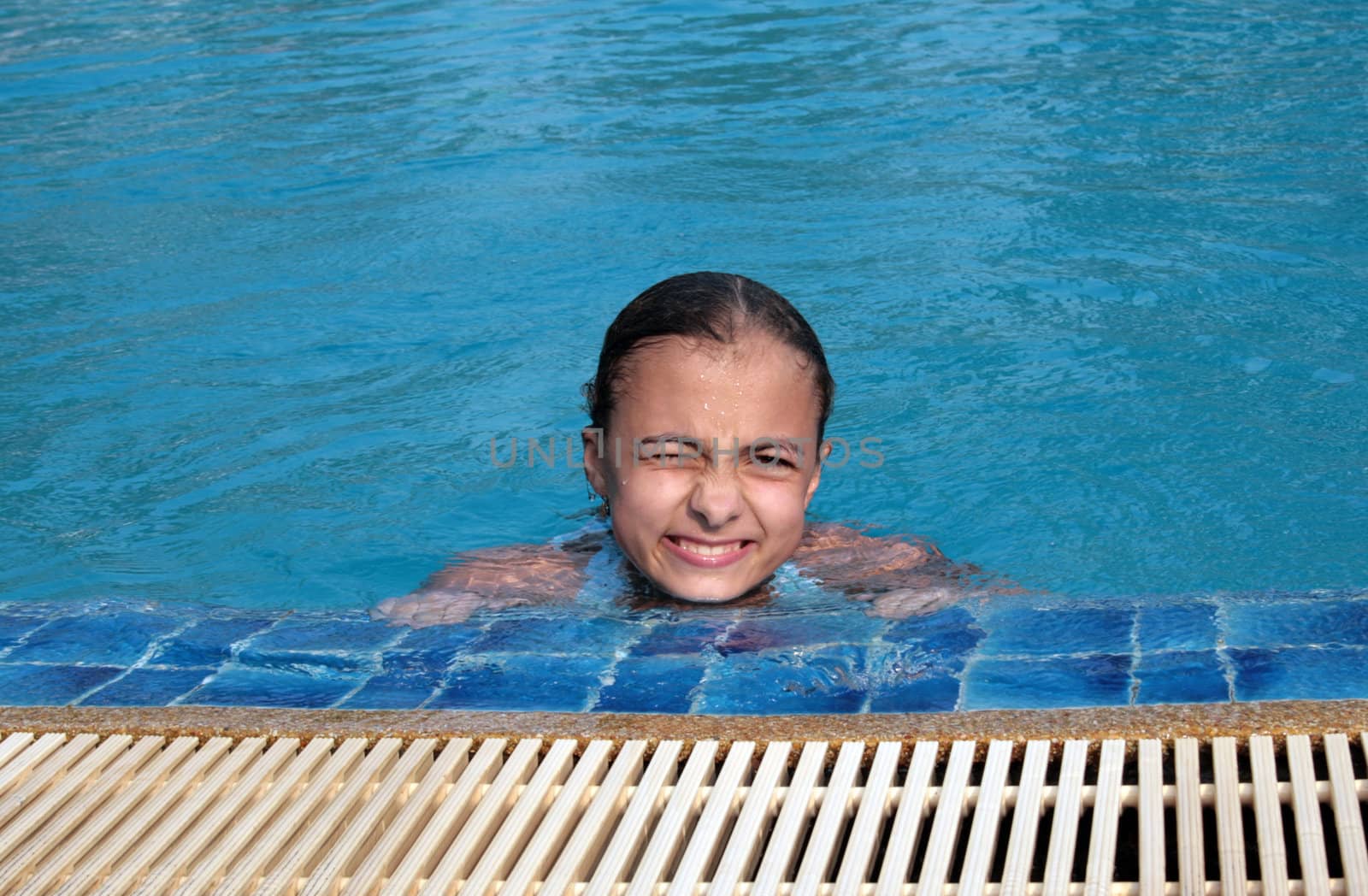 Beautiful girl in pool with blue water