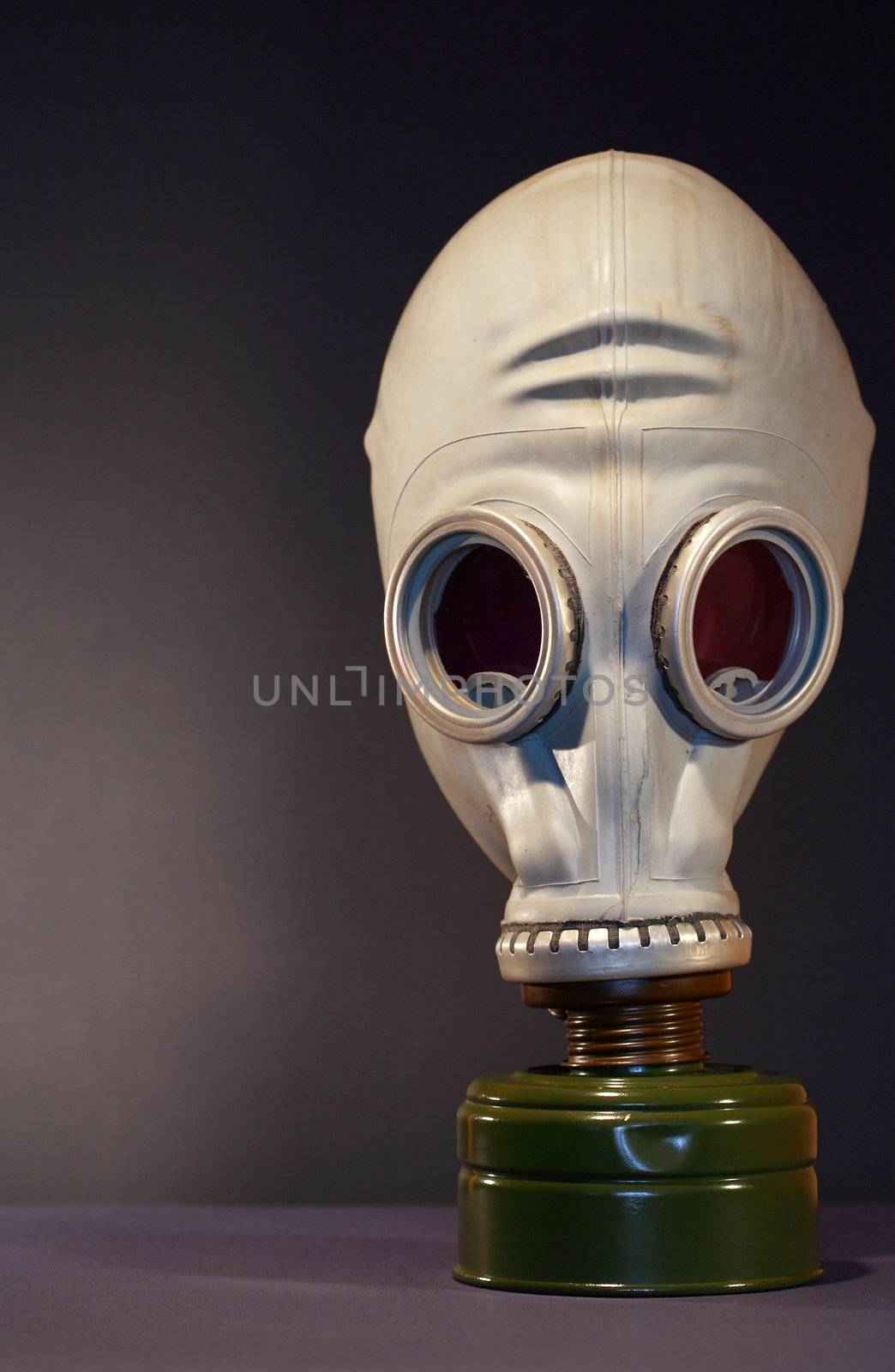Old gas mask standing on dark background with copy space