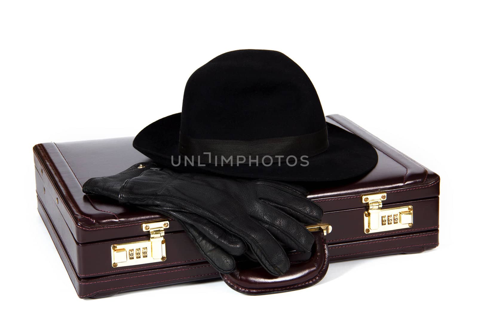 Suitcase with laying from above a hat and gloves on a white background