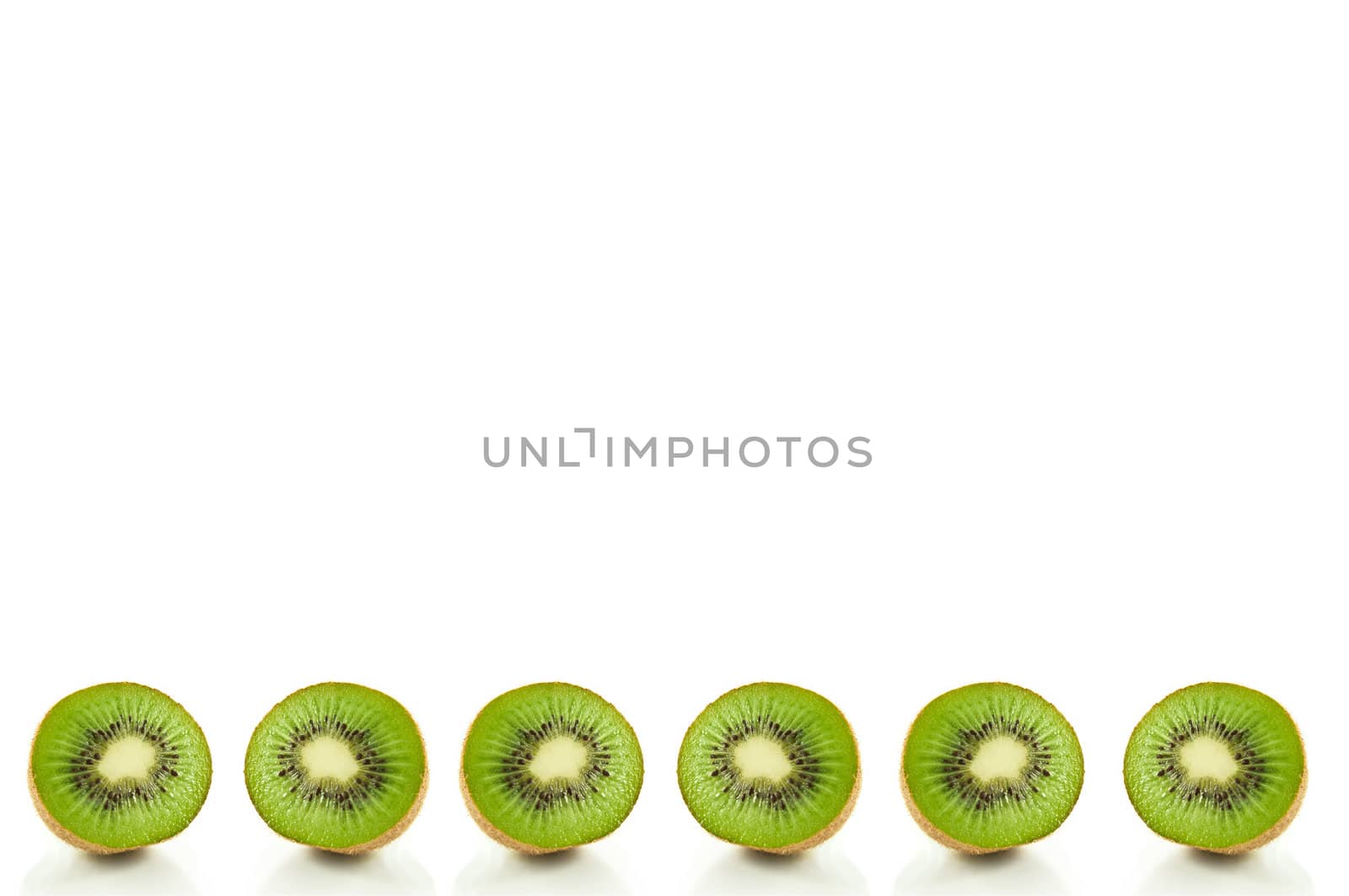 Six small kiwi fruit halves arranged in a horizontal line along the bottom of the image and over white.