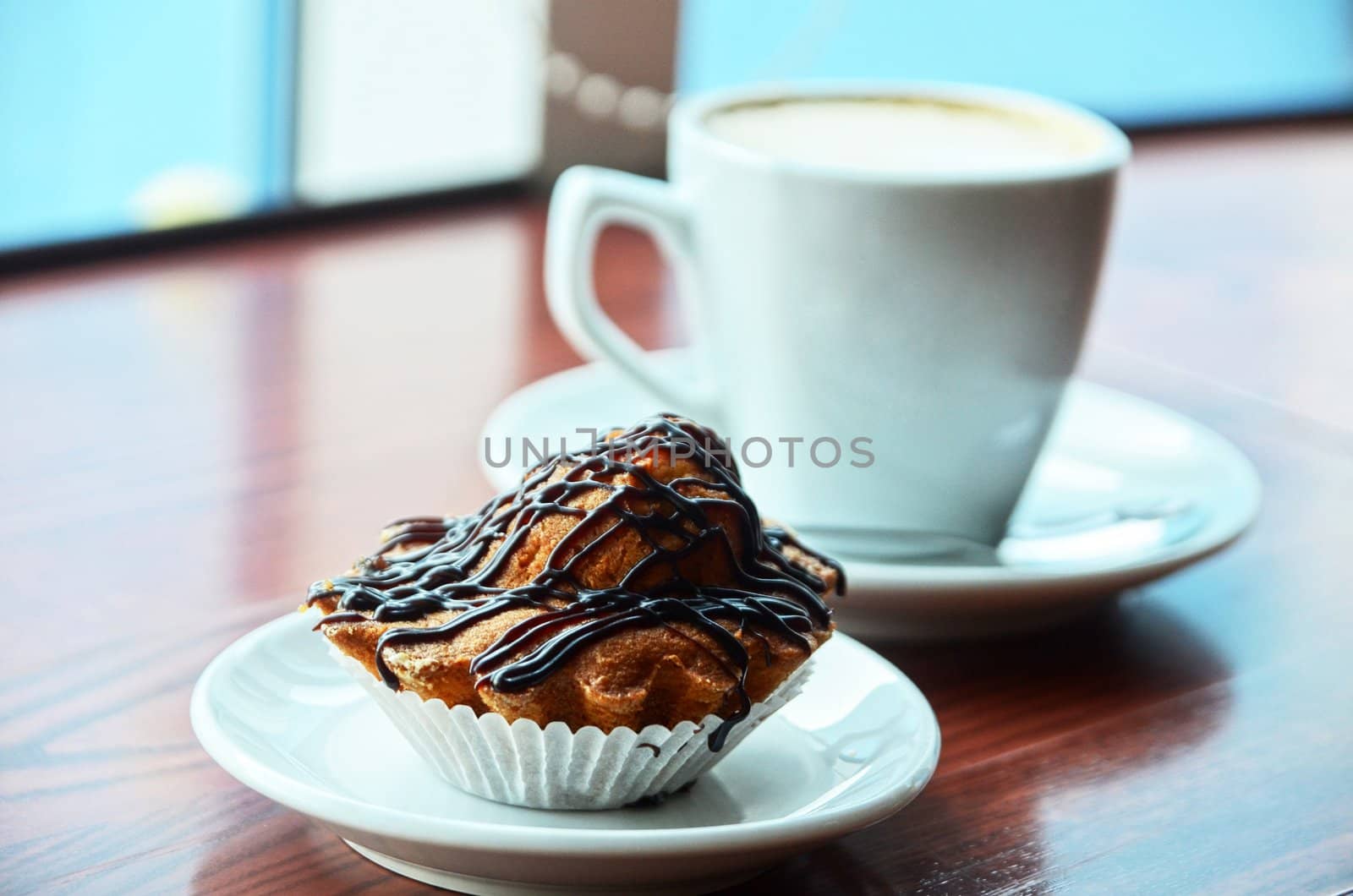 Chocolate muffins with and coffee cup on orange table