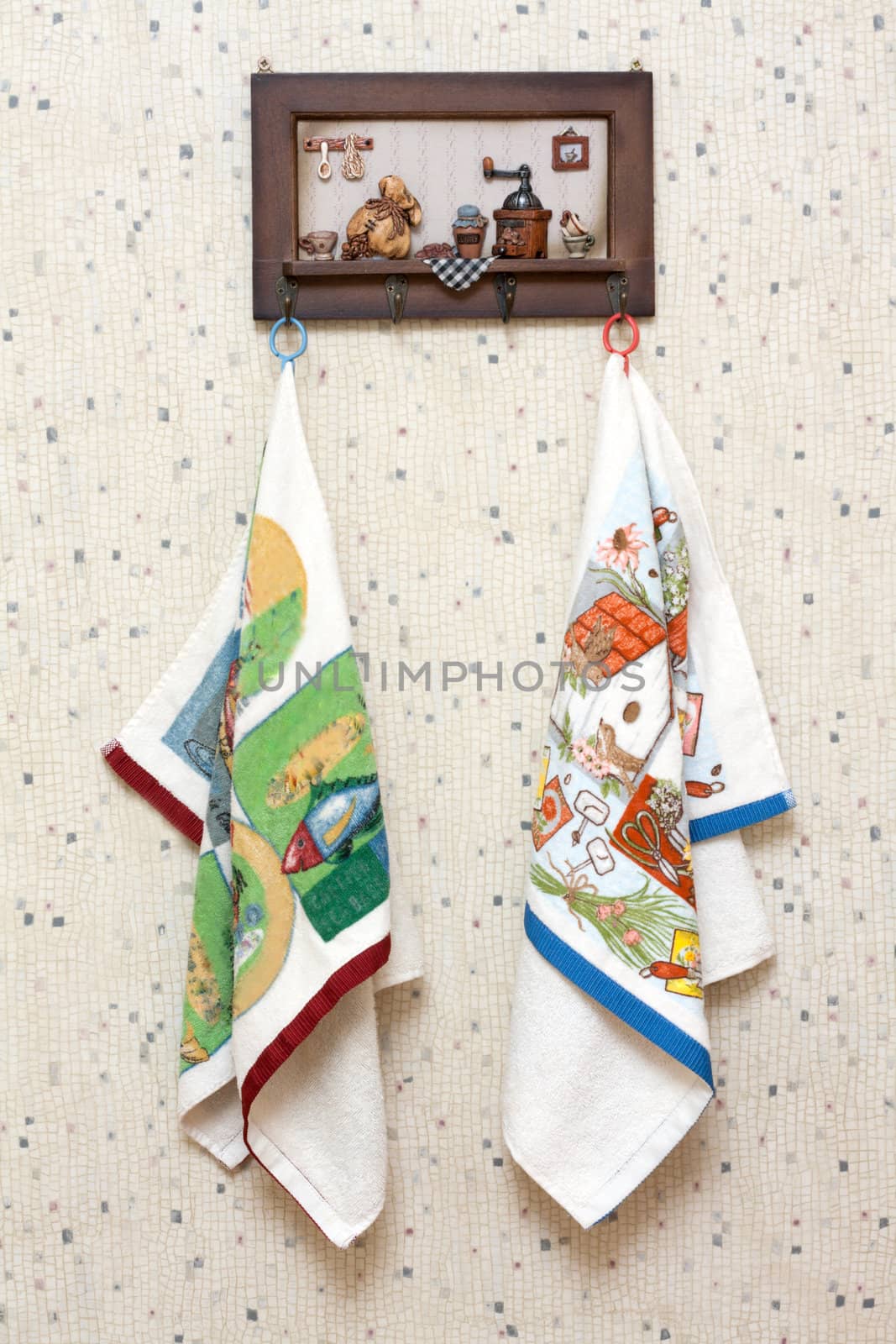 Dishtowels hung on wooden hatrack on background sulphur wallpaper