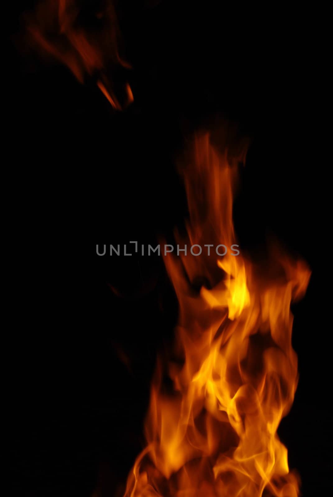 Tongue of orange flame isolated on black background