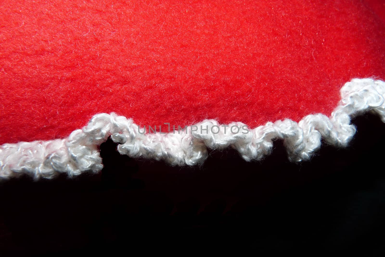Knitted edge of handmade pillow close-up fragment on black by Vitamin