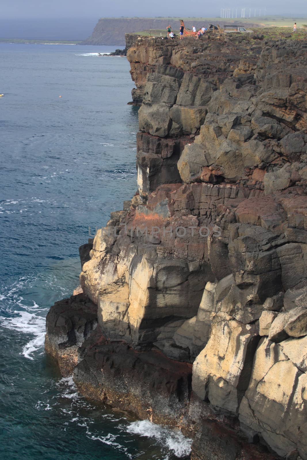 fisherman sport fishing off dangerous cliffs off coast of Hawaii Big Island by njene