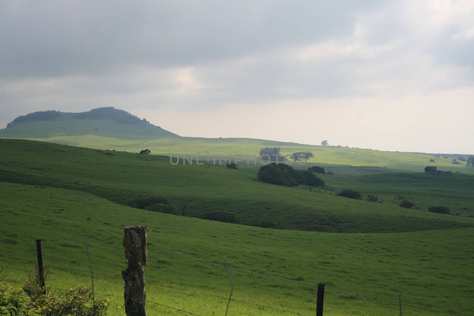 mountainside pasture with storm clouds overhead by njene