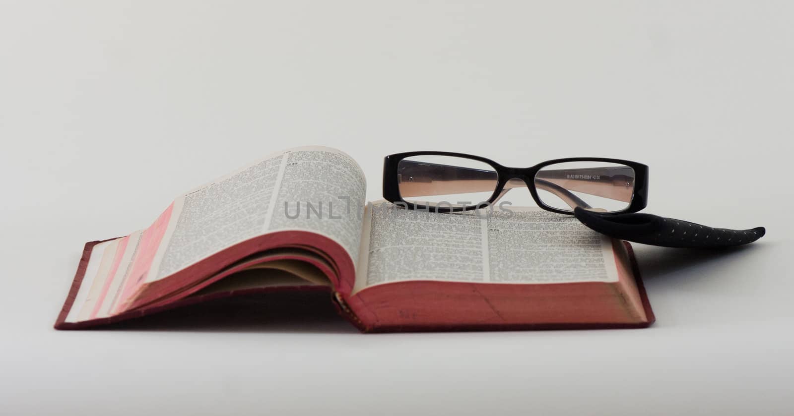 A pair of reading glasses resting on the bible.