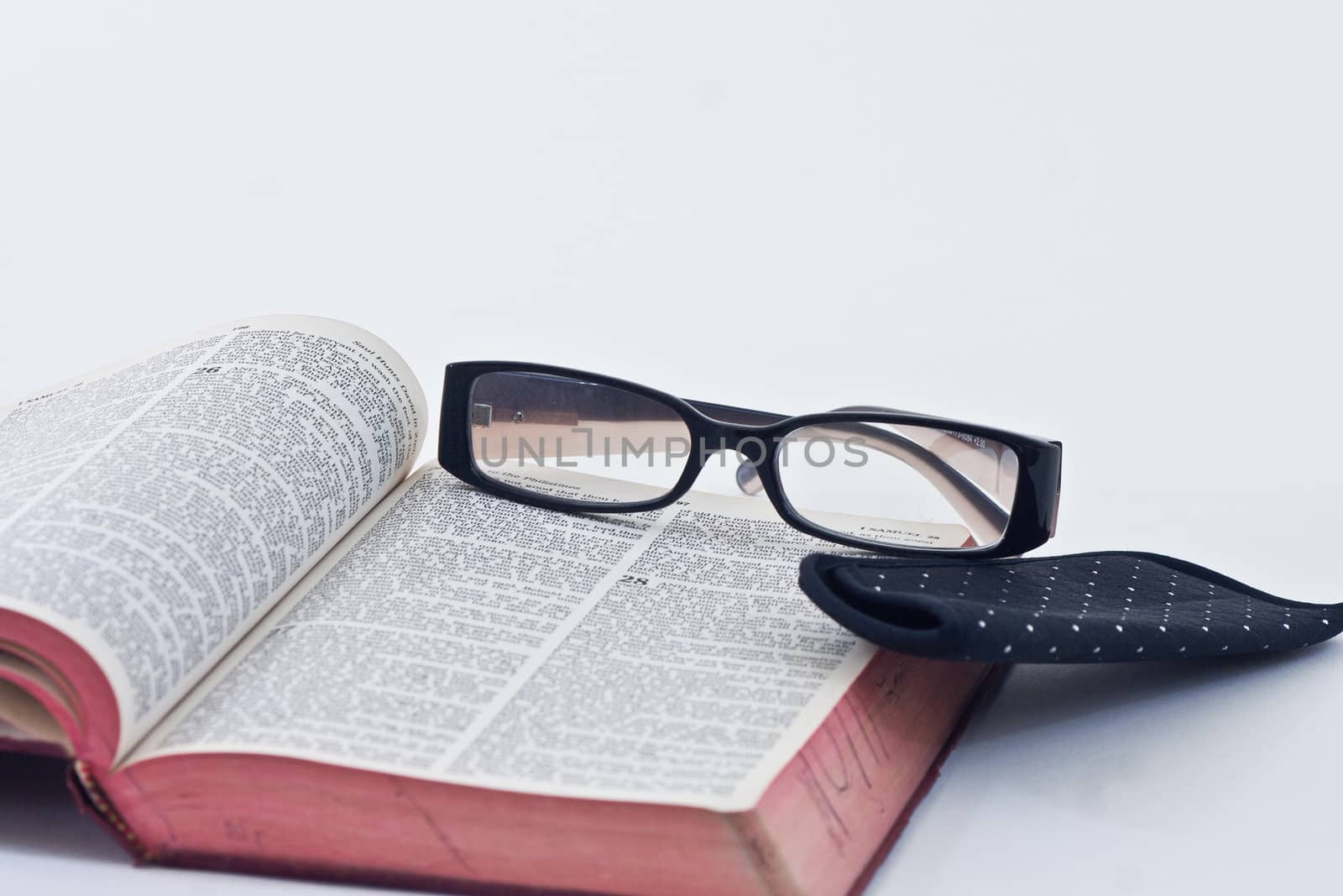 A pair of reading glasses resting on the bible.