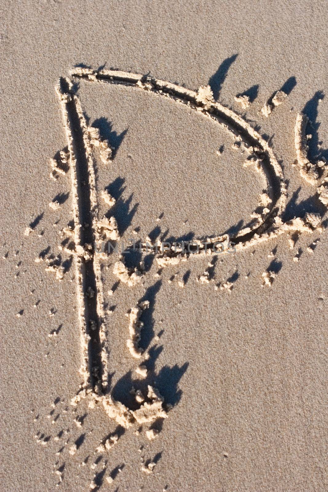 Letter P drawn in the sand. 
