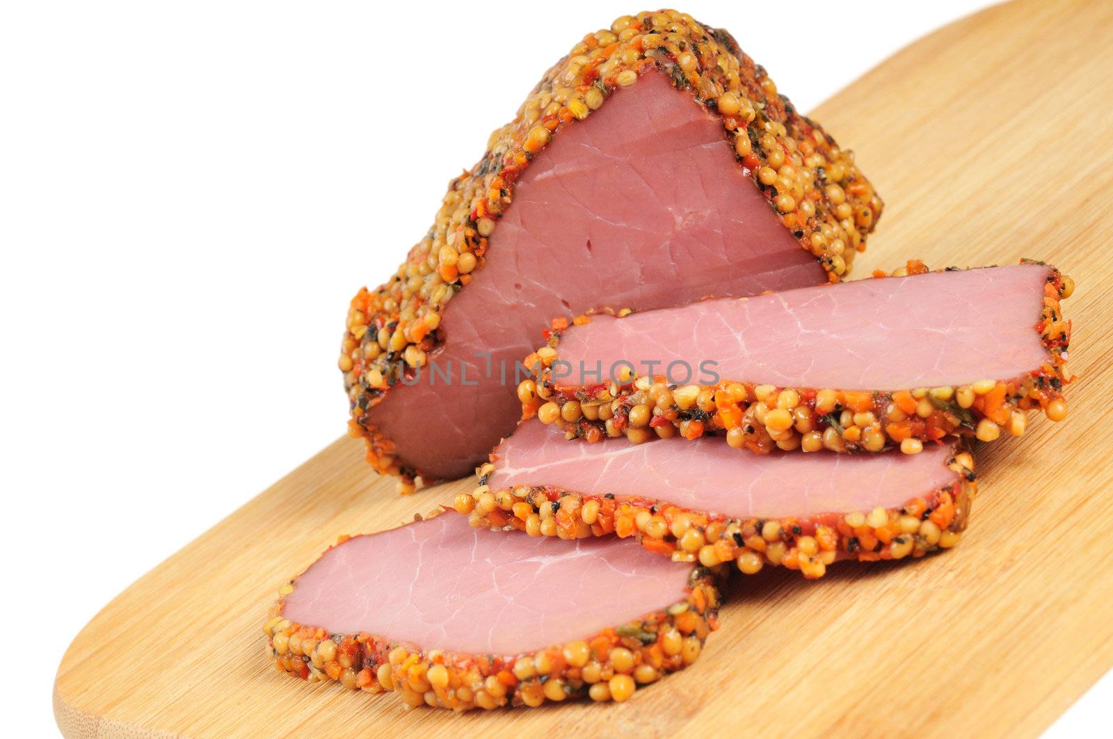 Piece of a ham with spices on a wooden board. Onwhite background.