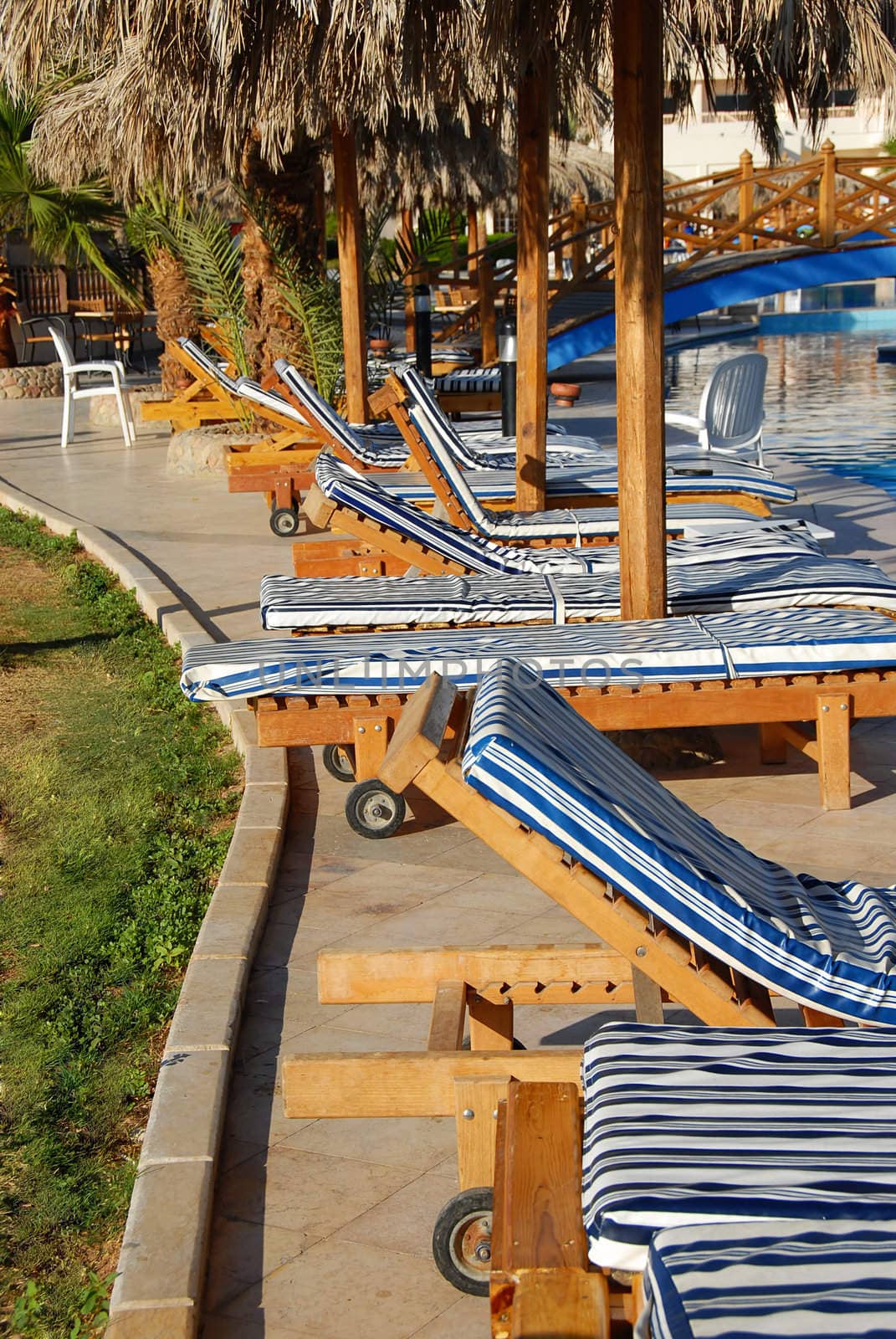 Folding chairs row by swimming pool by simply