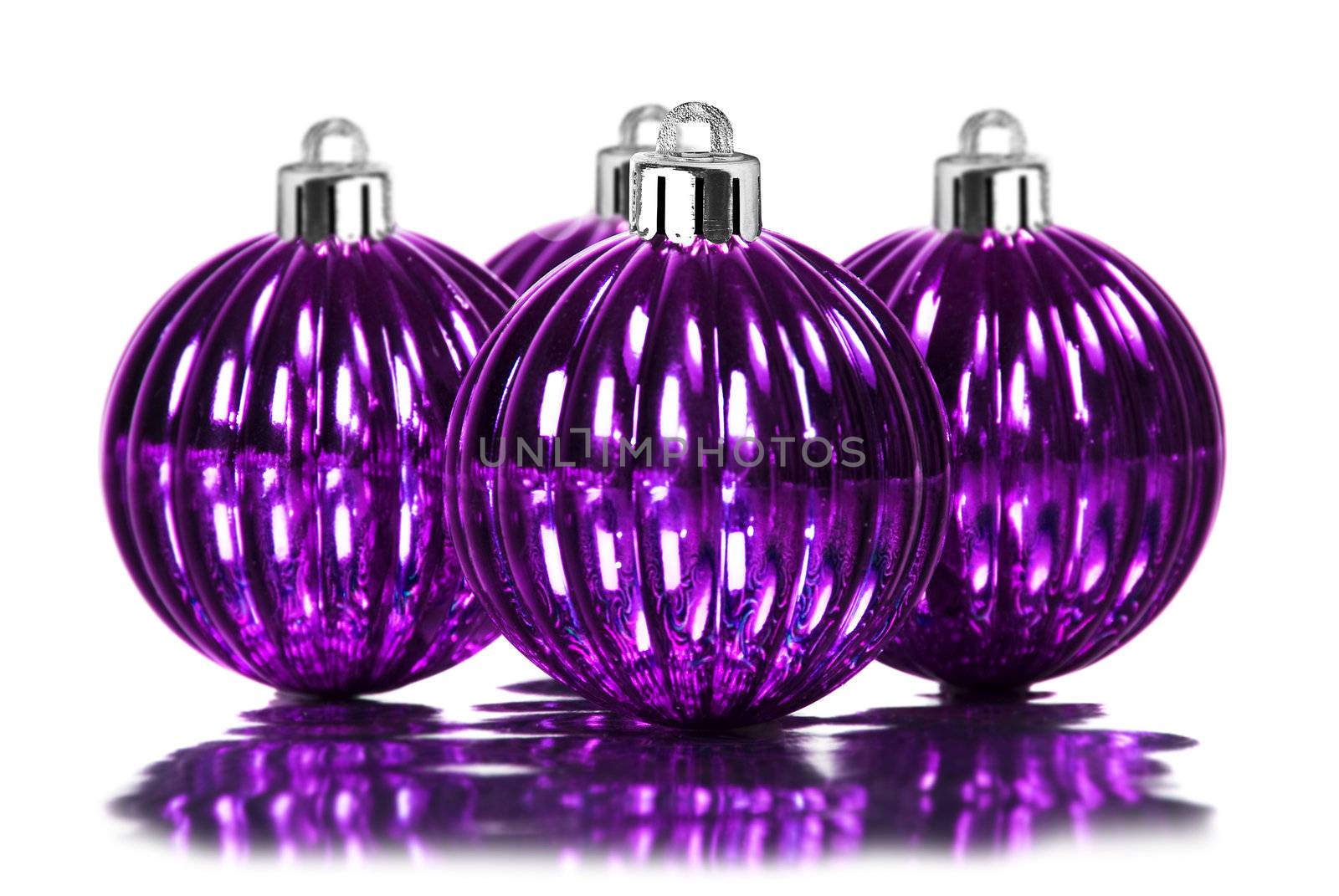 Purple christmas decoration baubles on white background with space for text by tish1