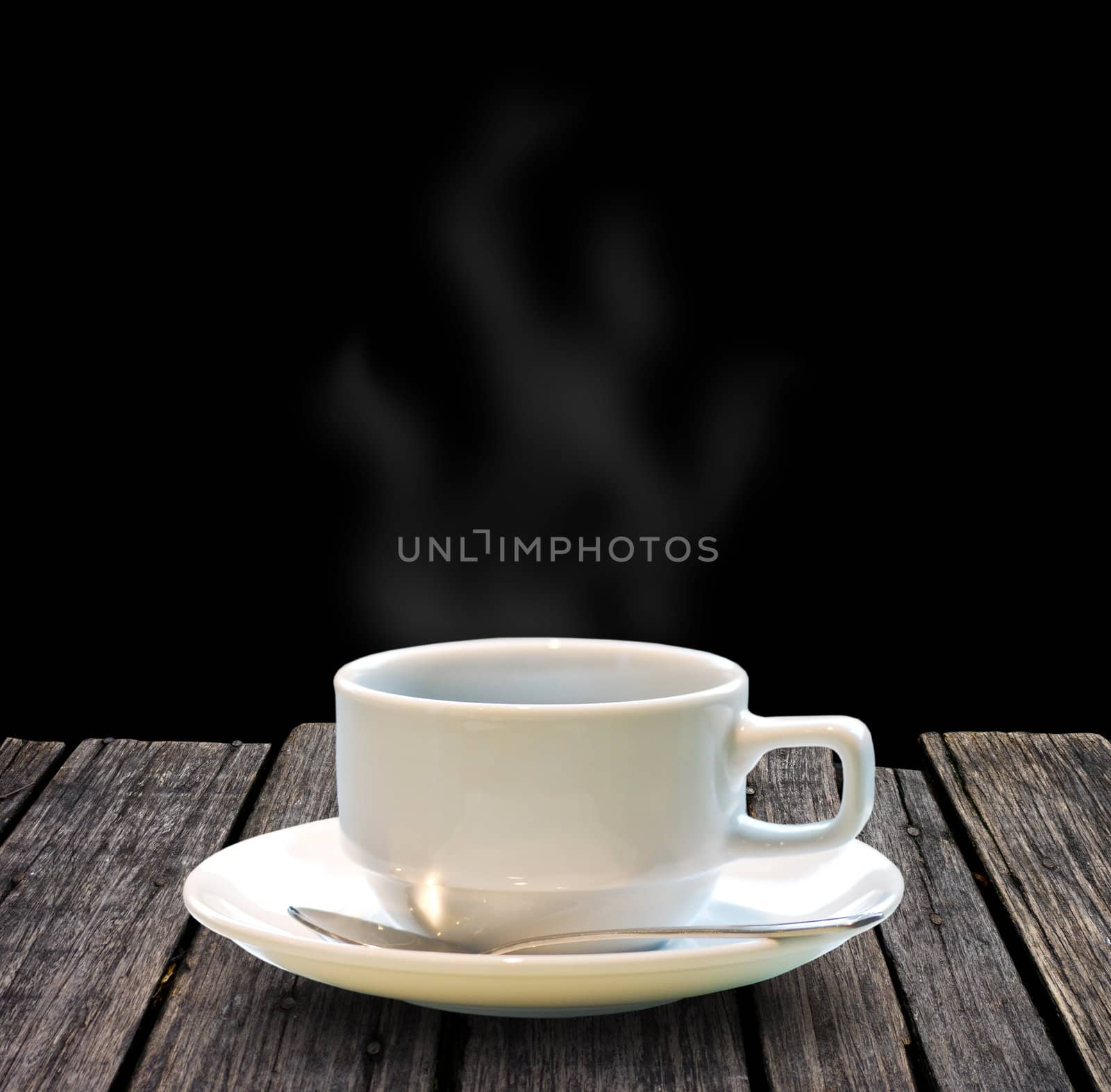 Hot coffee on wooden table with black background