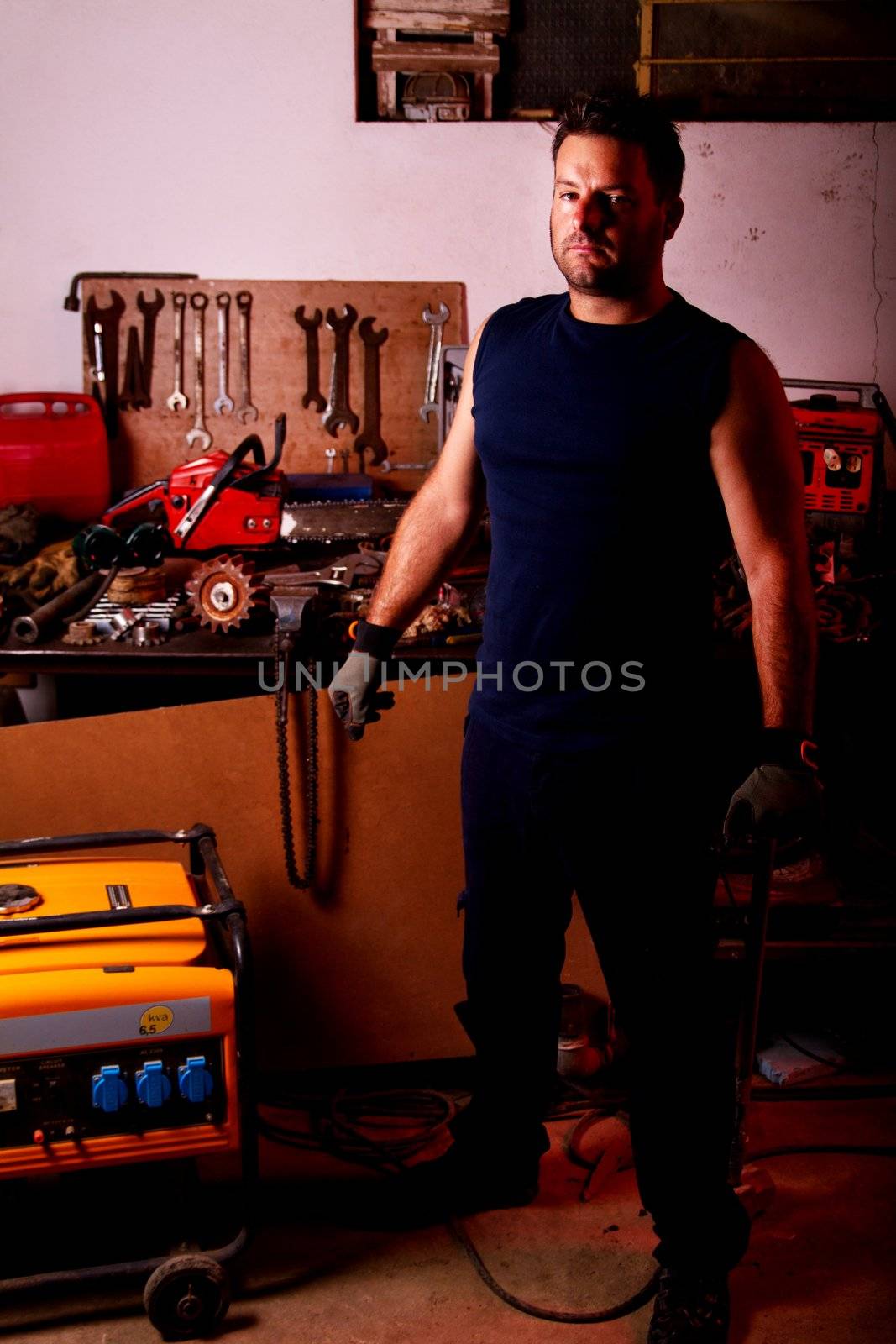 View of a mechanic man inside a garage with many tools.