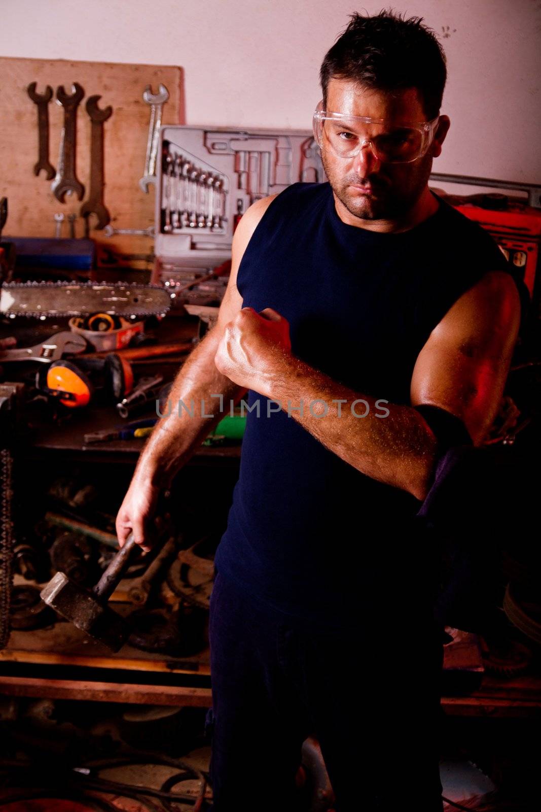 View of a garage mechanic man holding a hammer.