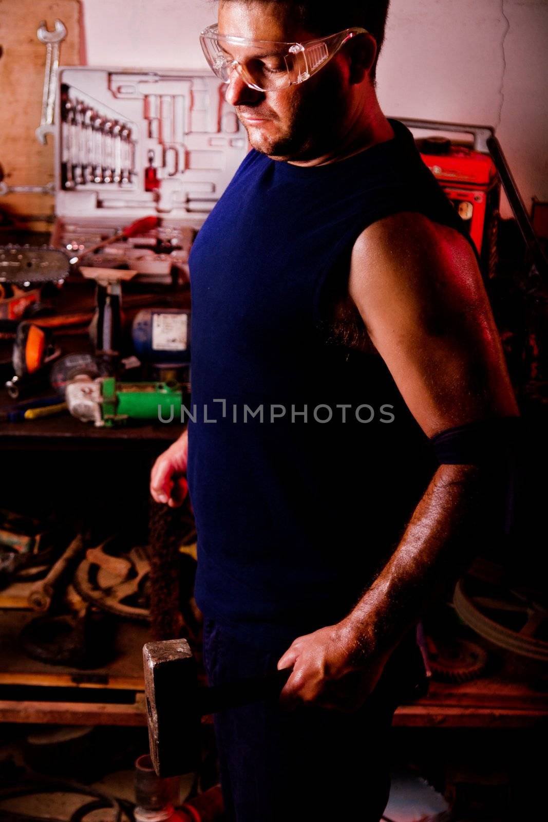 View of a garage mechanic man holding a hammer.