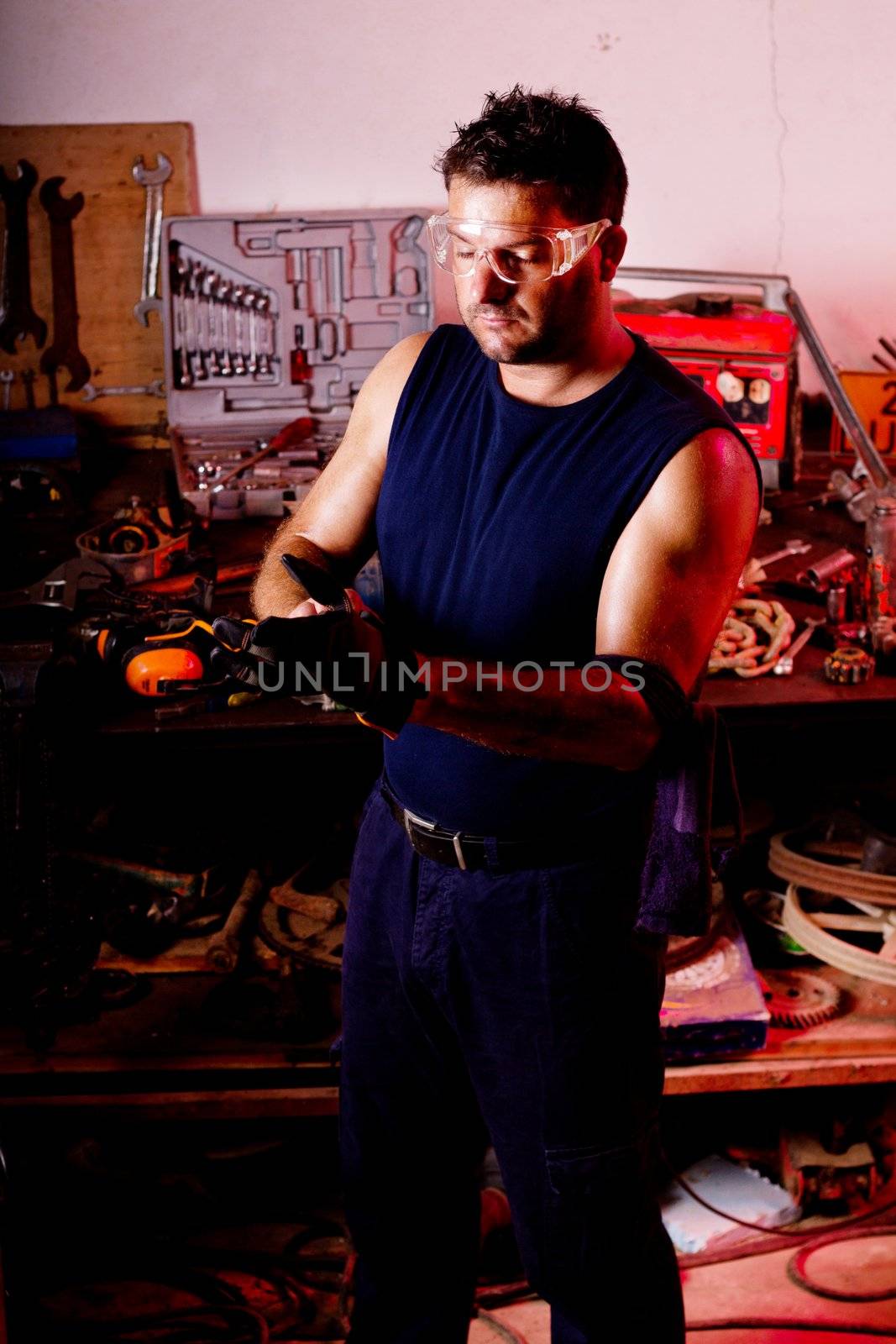 View of a garage mechanic man putting some protective gloves.