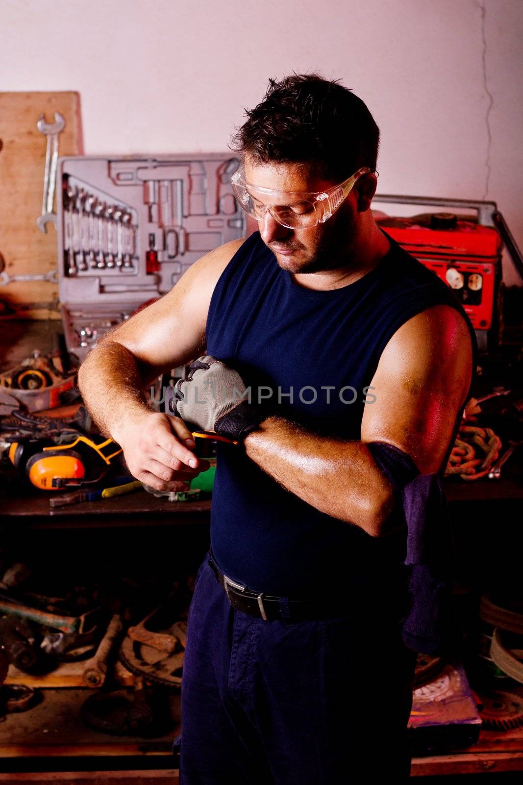 View of a garage mechanic man putting some protective gloves.