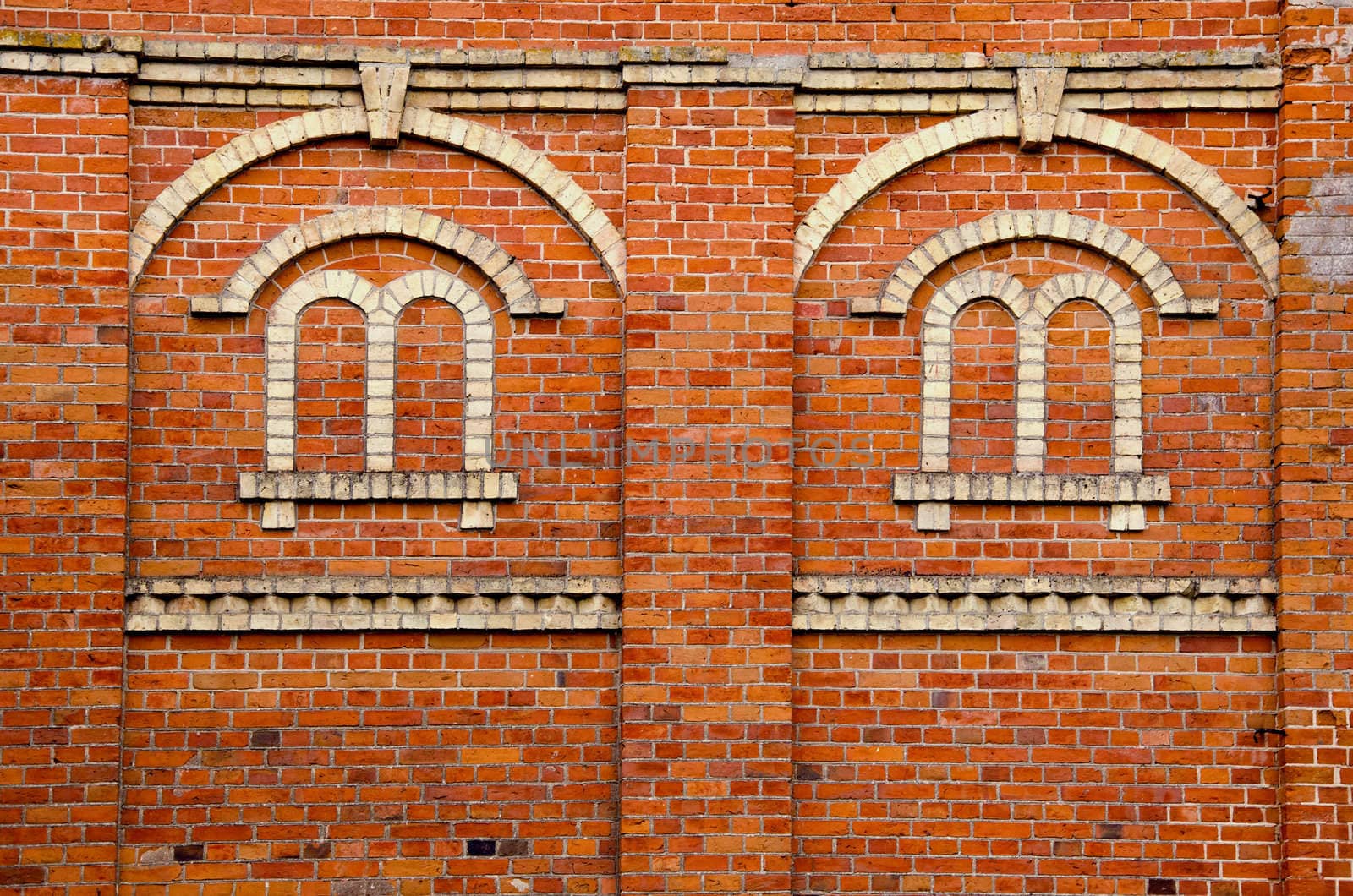 Red brick wall with window imitation made of white bricks.