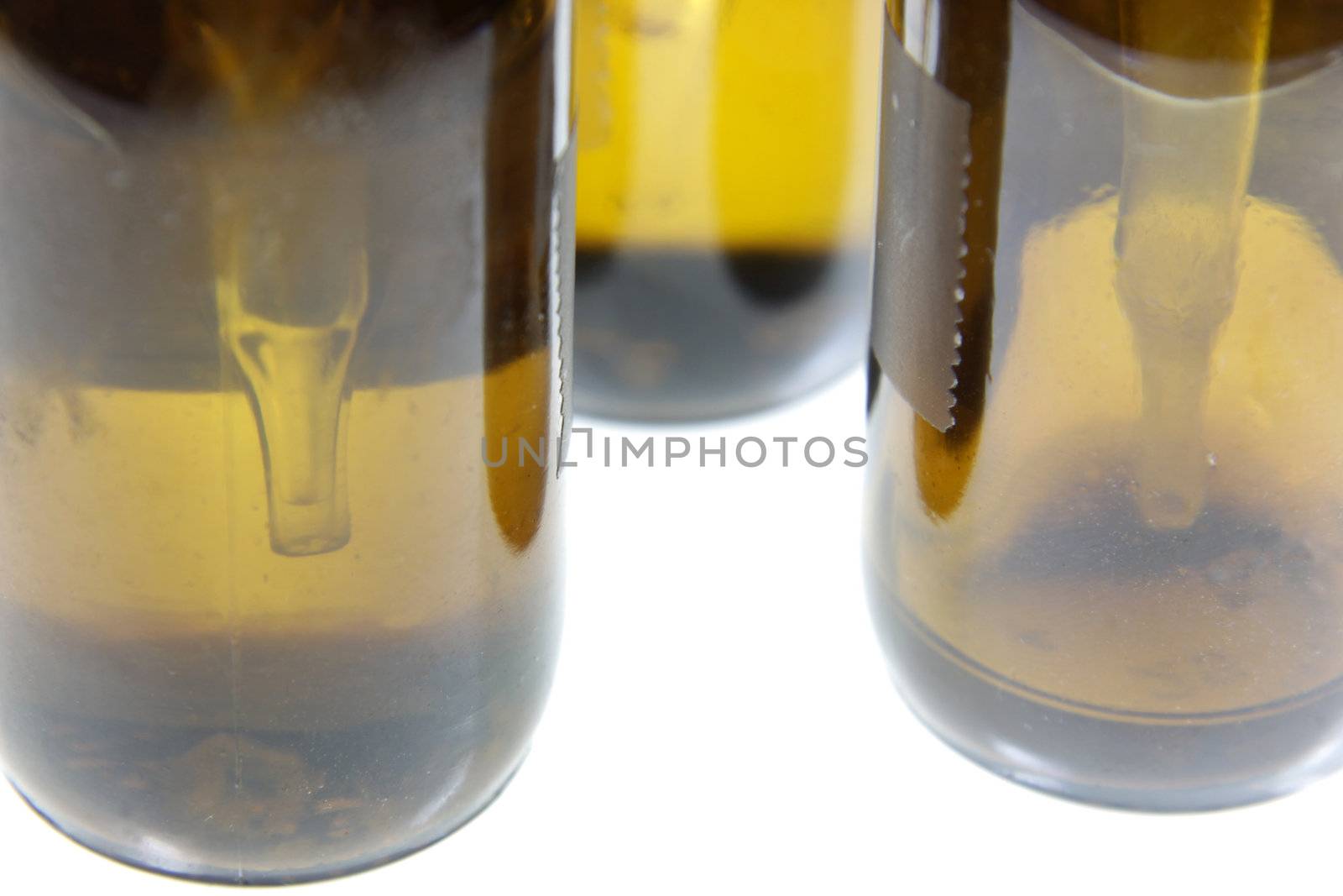 An extreme close-up of droppers in bottles containing naturopathic medicine, isolated on a white background.
