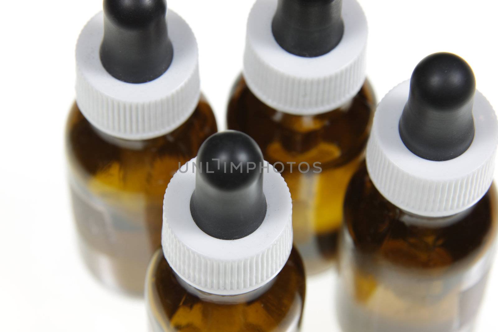 Four dropper bottles containing naturopathic medicine, isolated on a white background.
