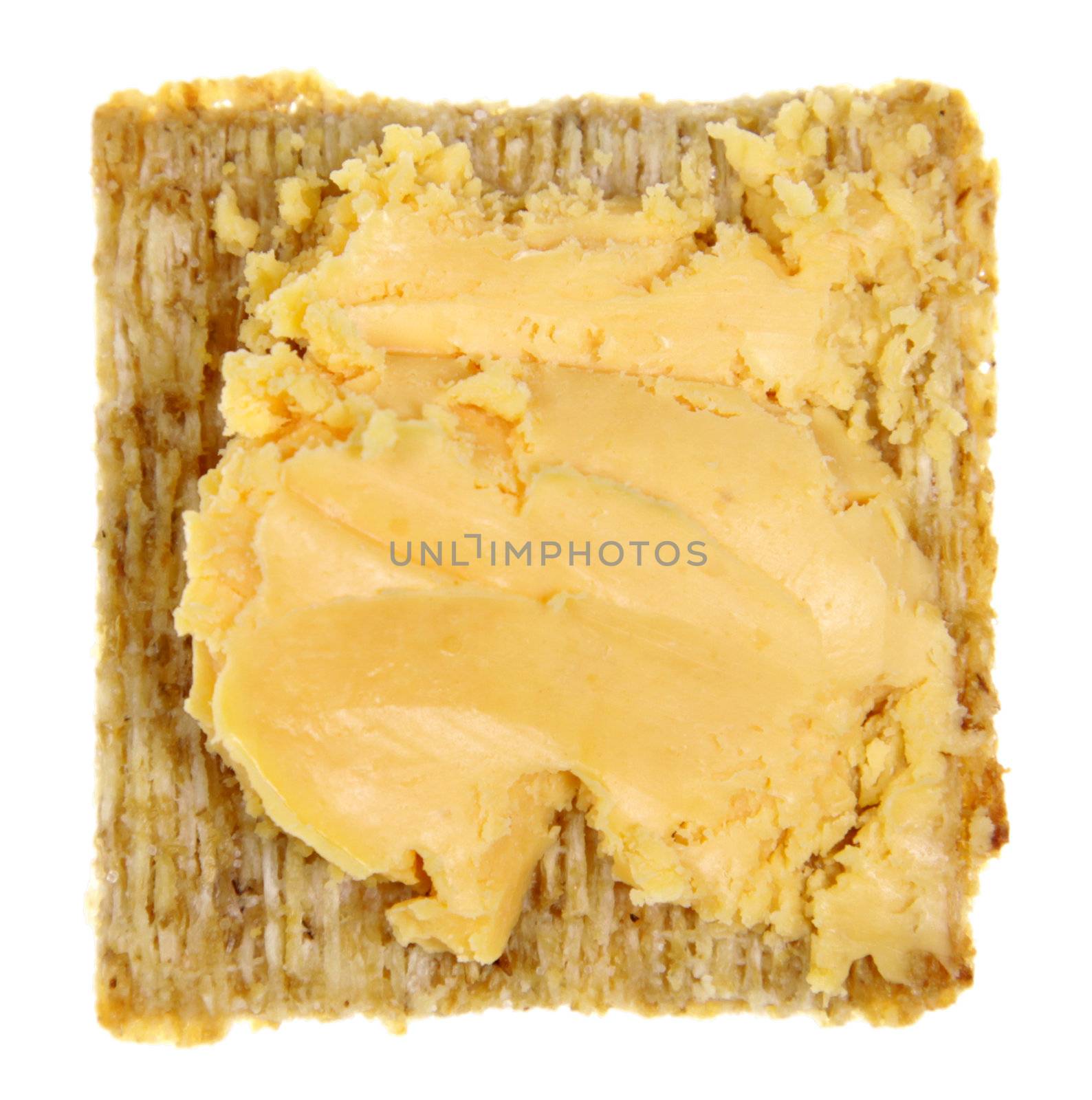 A square whole wheat cracker with cheese isolated on white.
