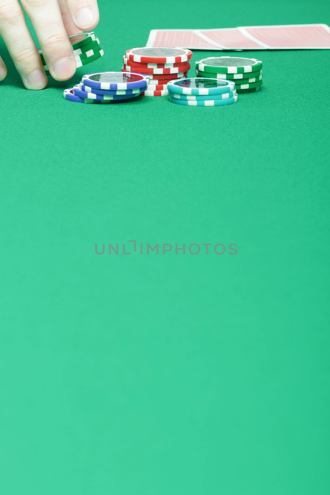 man's hand collects the chips with game table

