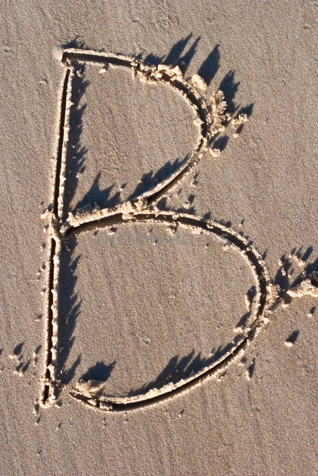Letter B drawn in the sand. 