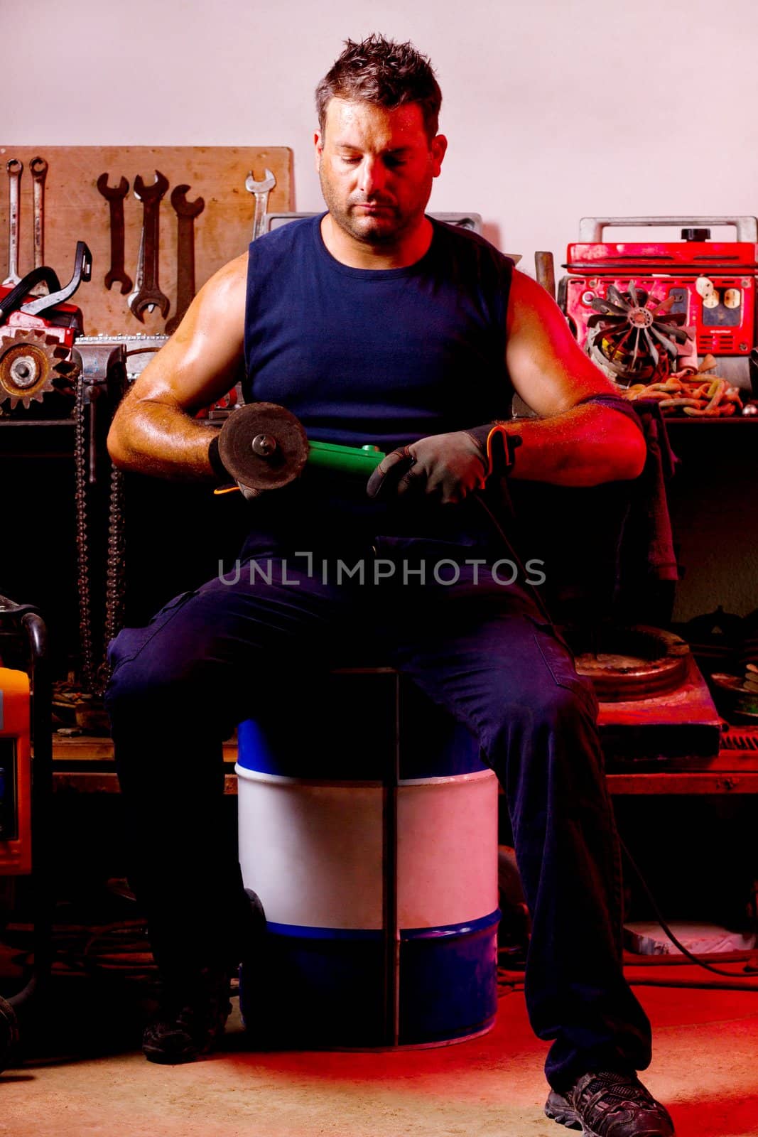 View of a garage mechanic man holding a power saw.