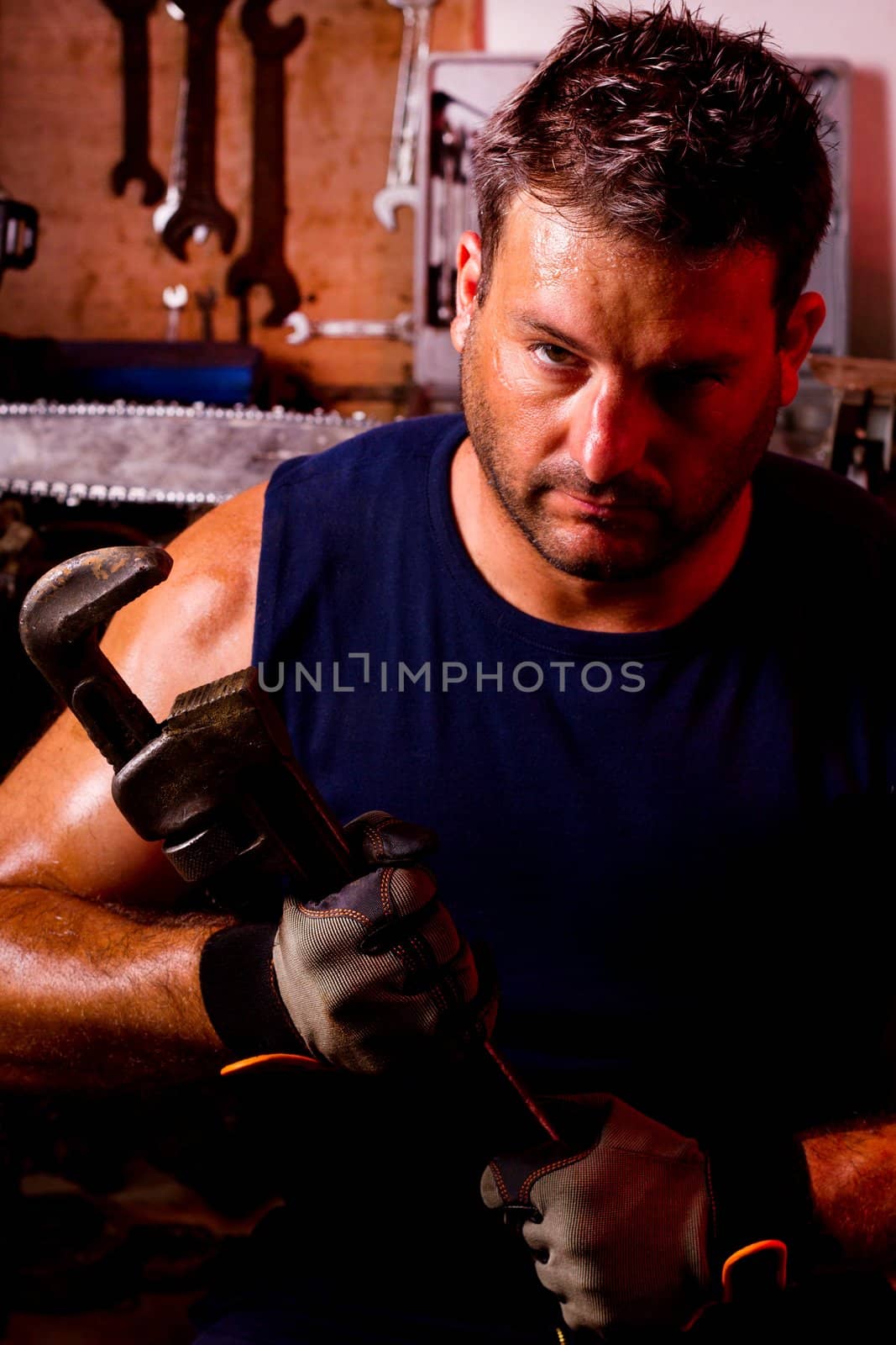 View of a garage mechanic man holding an adjustable spanner.