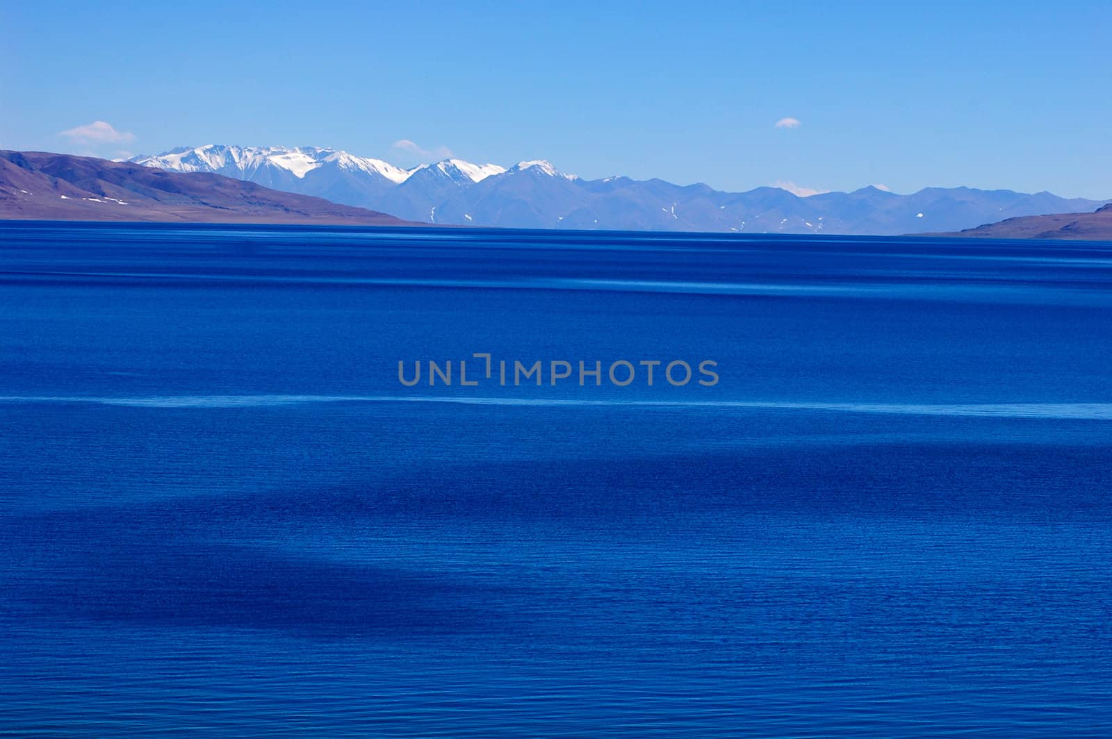Landscape of blue lake and snow covered mountains in the highlands of Tibet