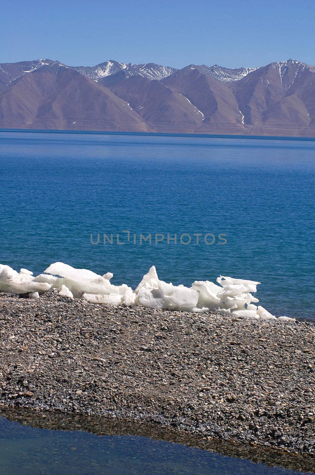Landscape of blue lake and snow covered mountains in the highlands of Tibet
