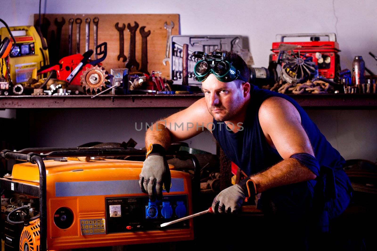 View of a garage mechanic man holding a screwdriver.