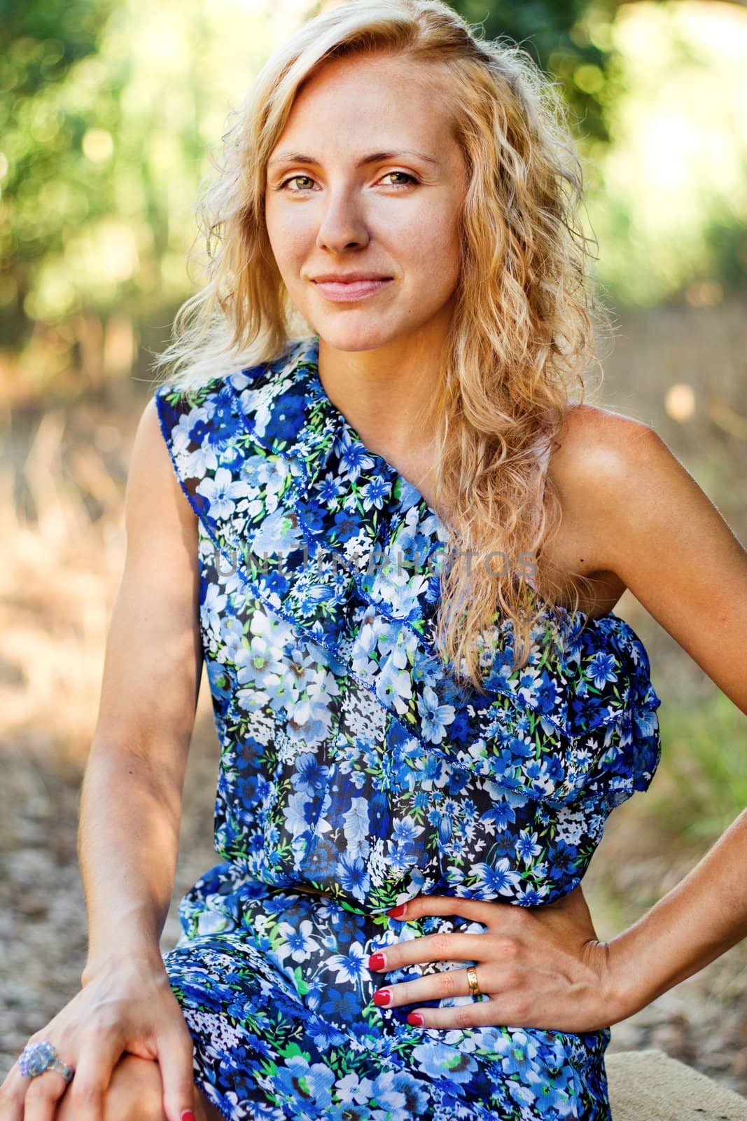 View of a beautiful young girl with a blue dress on the forest.