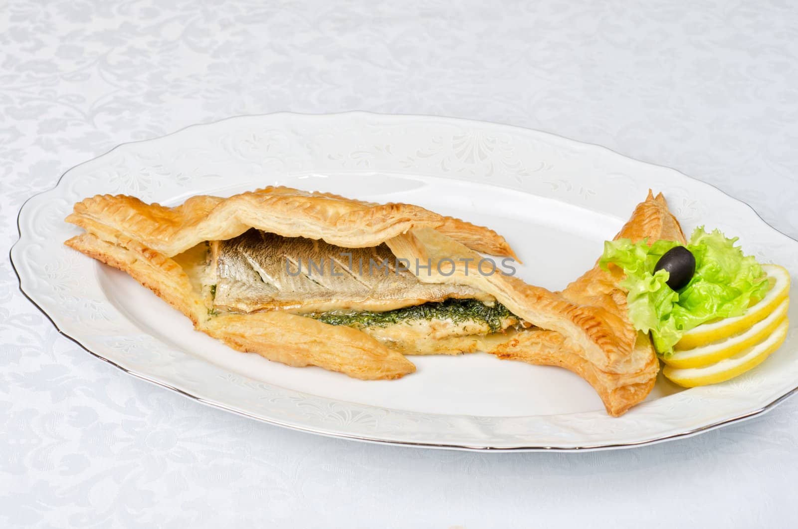 tasty dish of trout fish baked with greens at dough