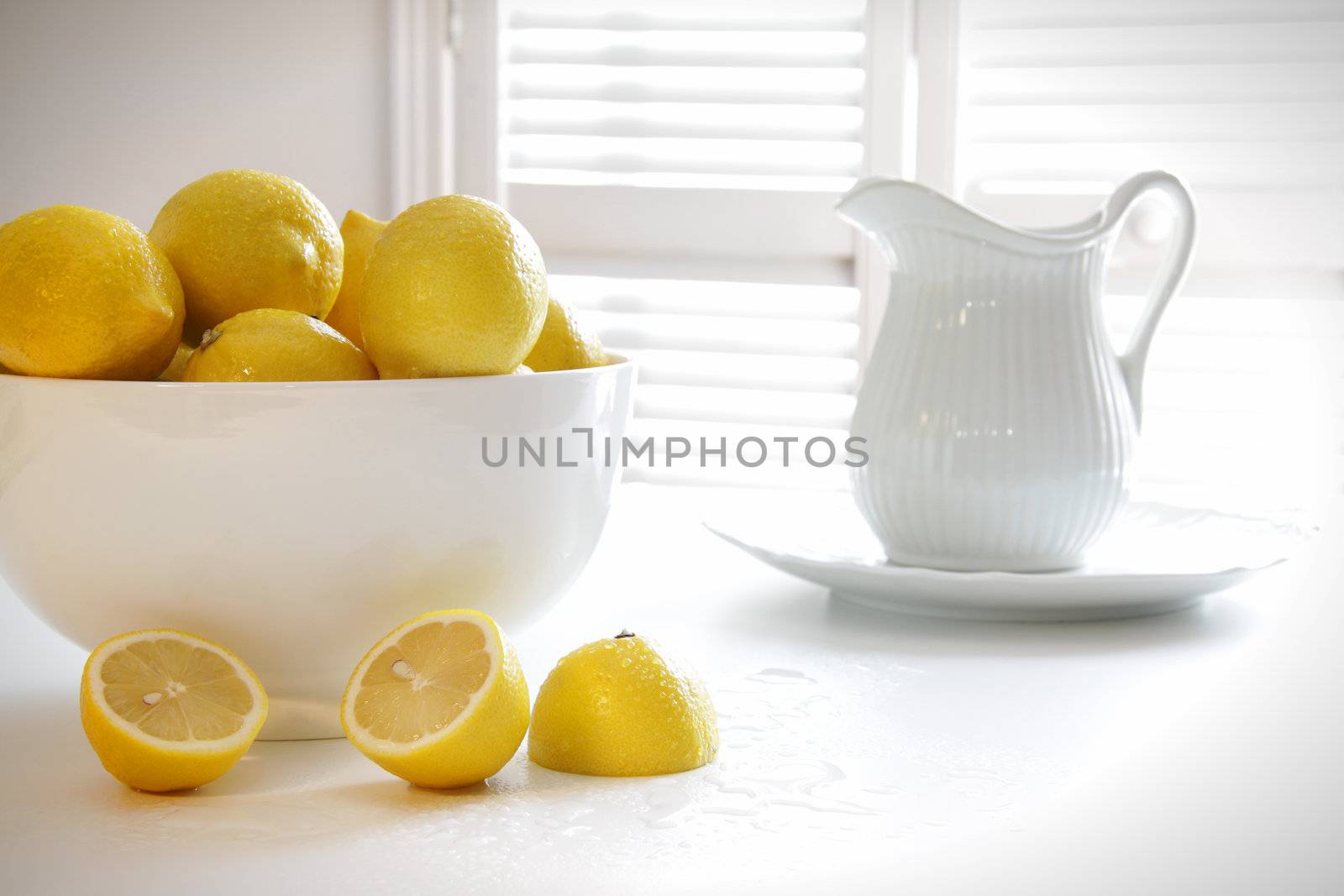 Lemons in large bowl on table by Sandralise