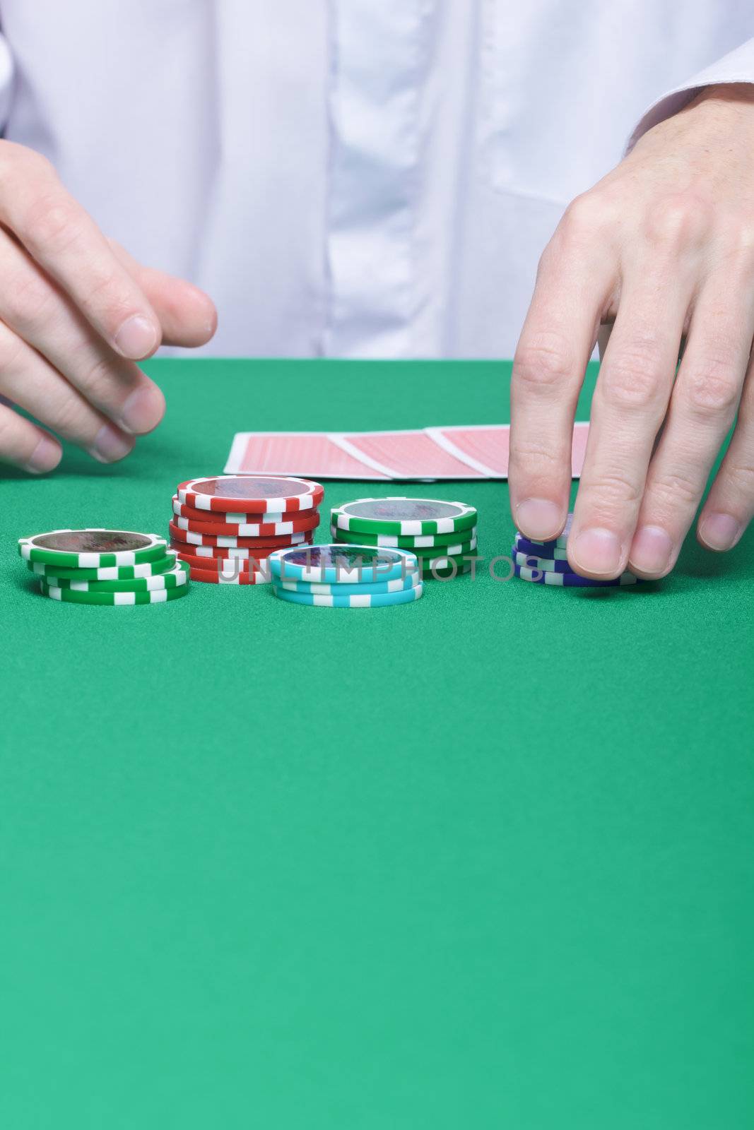 man's hand collects the chips with game table
