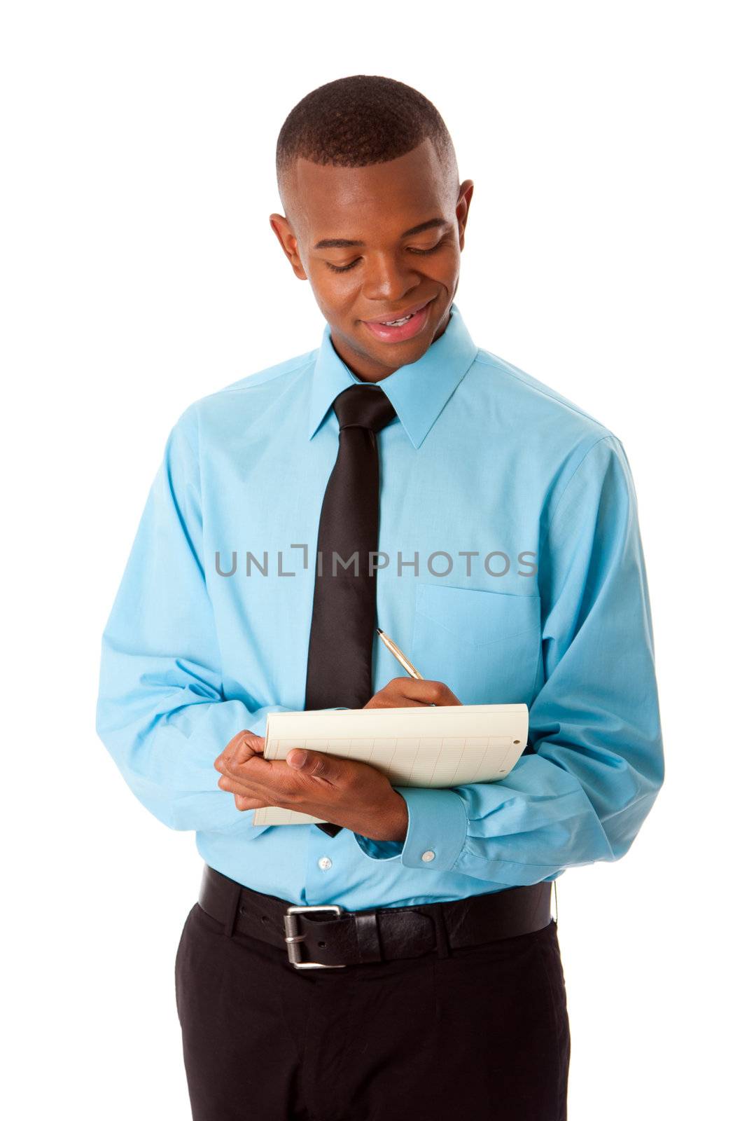 Handsome happy young male corporate MBA business student in blue shirt and black tie writing ideas notes on notepad, isolated.