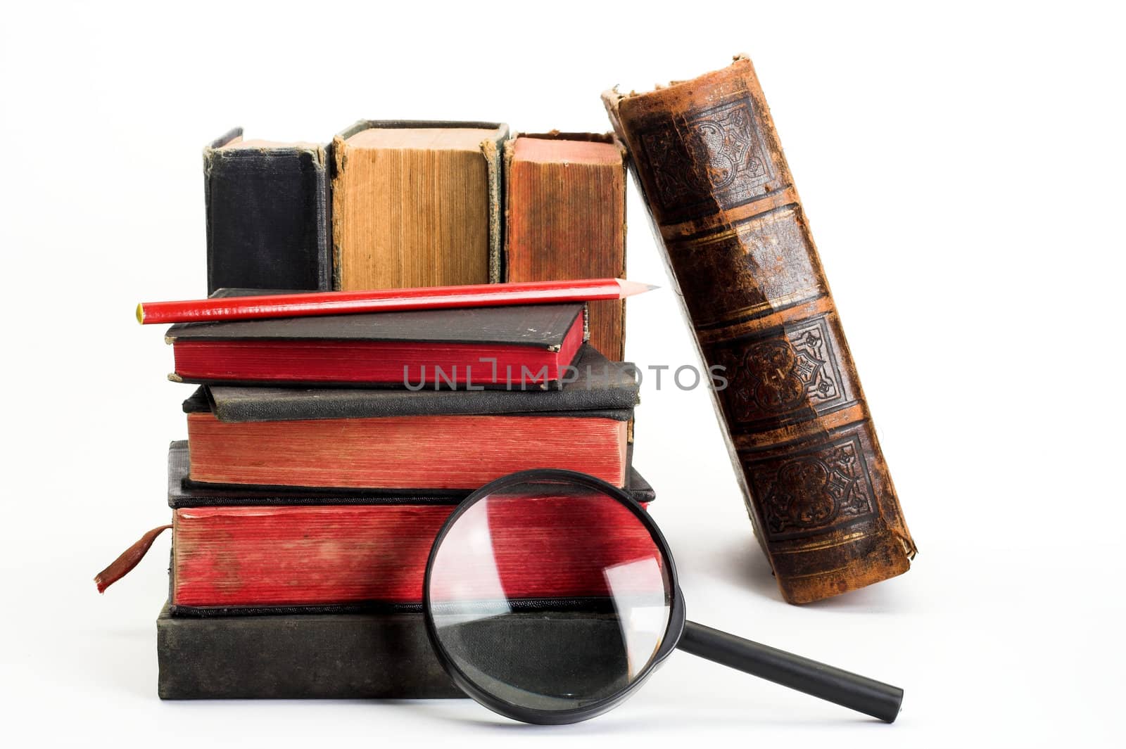  stack of old books and magnifier, close up
