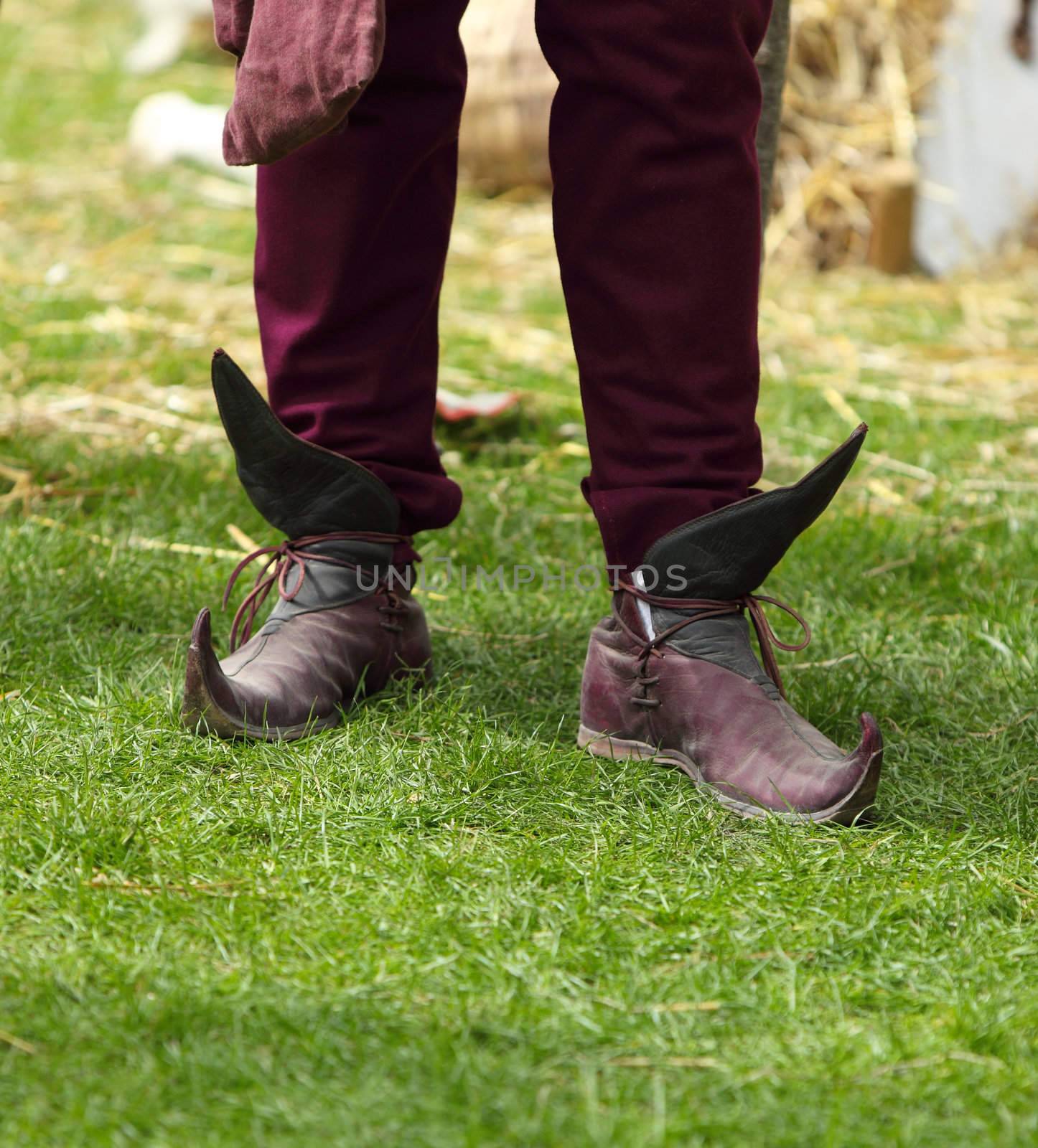 Close-up of specific medieval shoes (long toed shoes) on grass during a medieval festival. They have leather soles and multilayered leather heel made of specially hardened leather.They were popular in 12th-13th centuries in Europe.