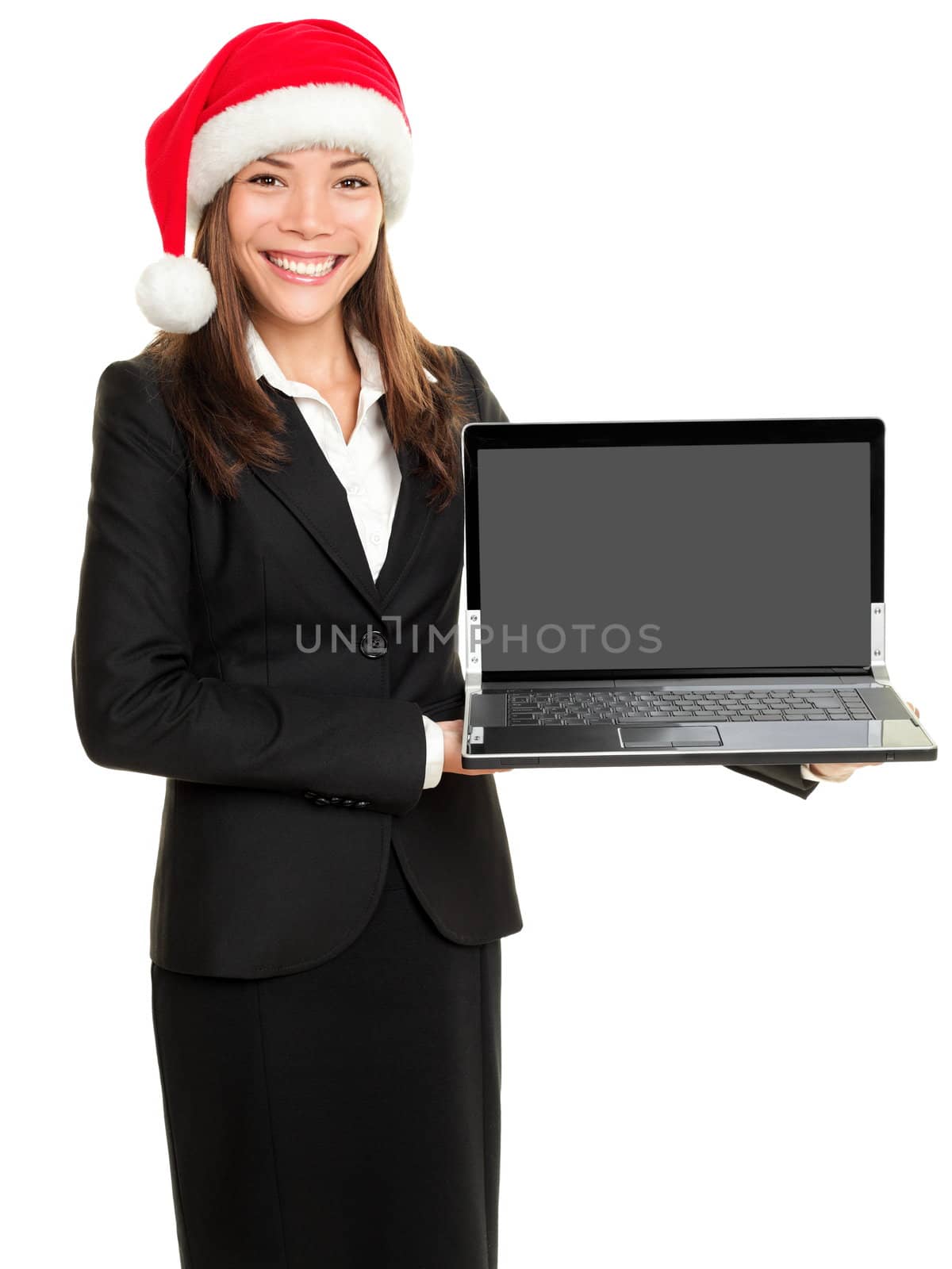 Christmas business woman holding computer laptop wearing santa hat. Businesswoman showing notebook PC screen with copy space for text or message. Multi cultural Asian Caucasian female model isolated on white background.